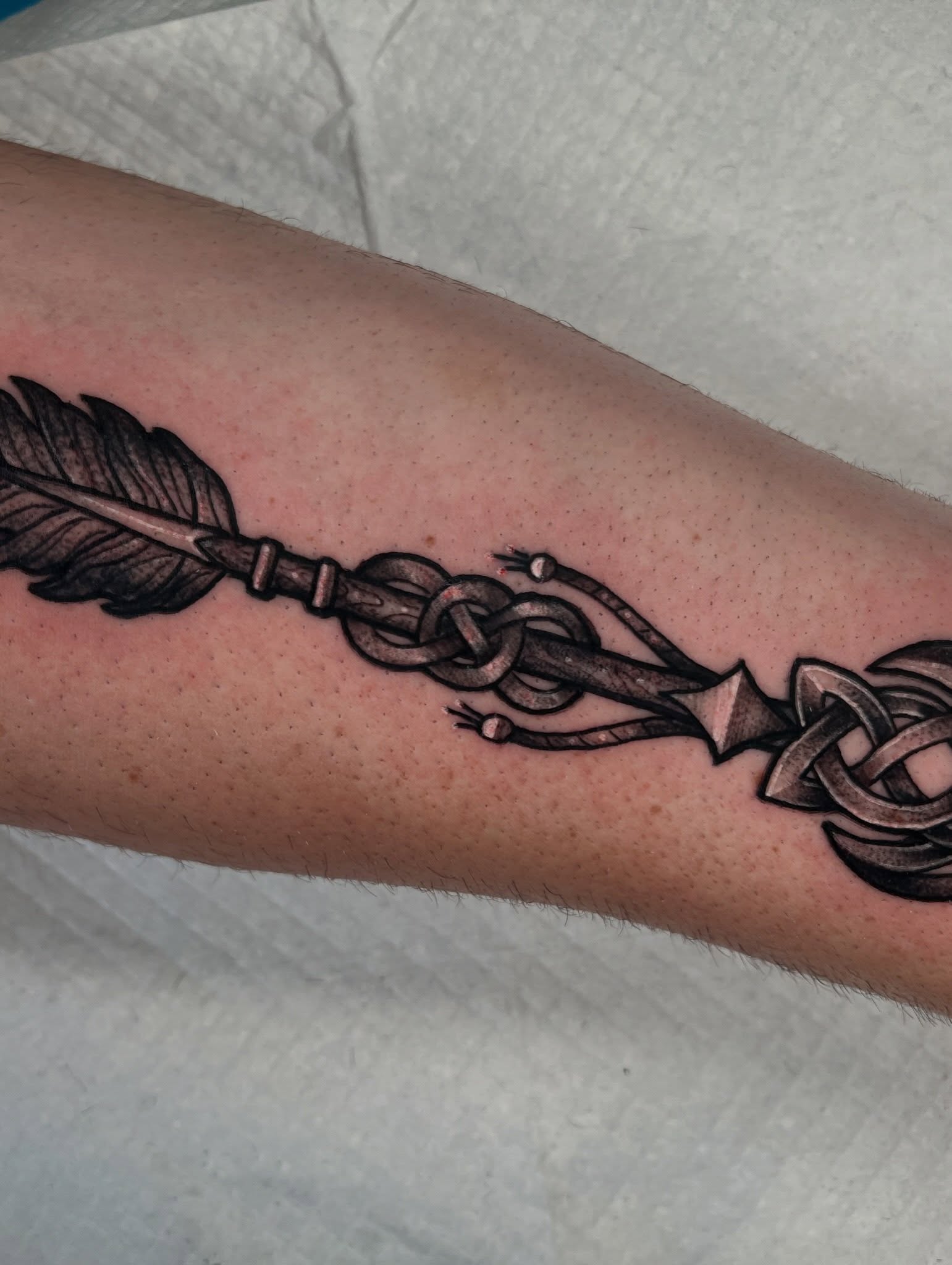 Arrow with knot black and grey tattoo on the forearm by Brandon Durbin