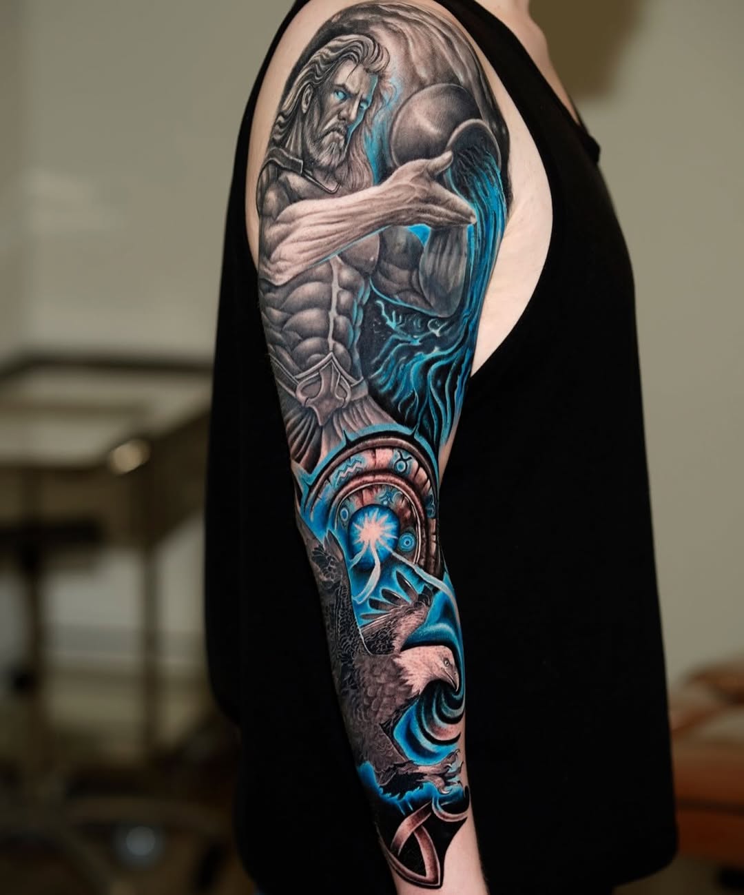 Man pouring water, eagle, celestial elements realism tattoo on the upper arm by David Gordon