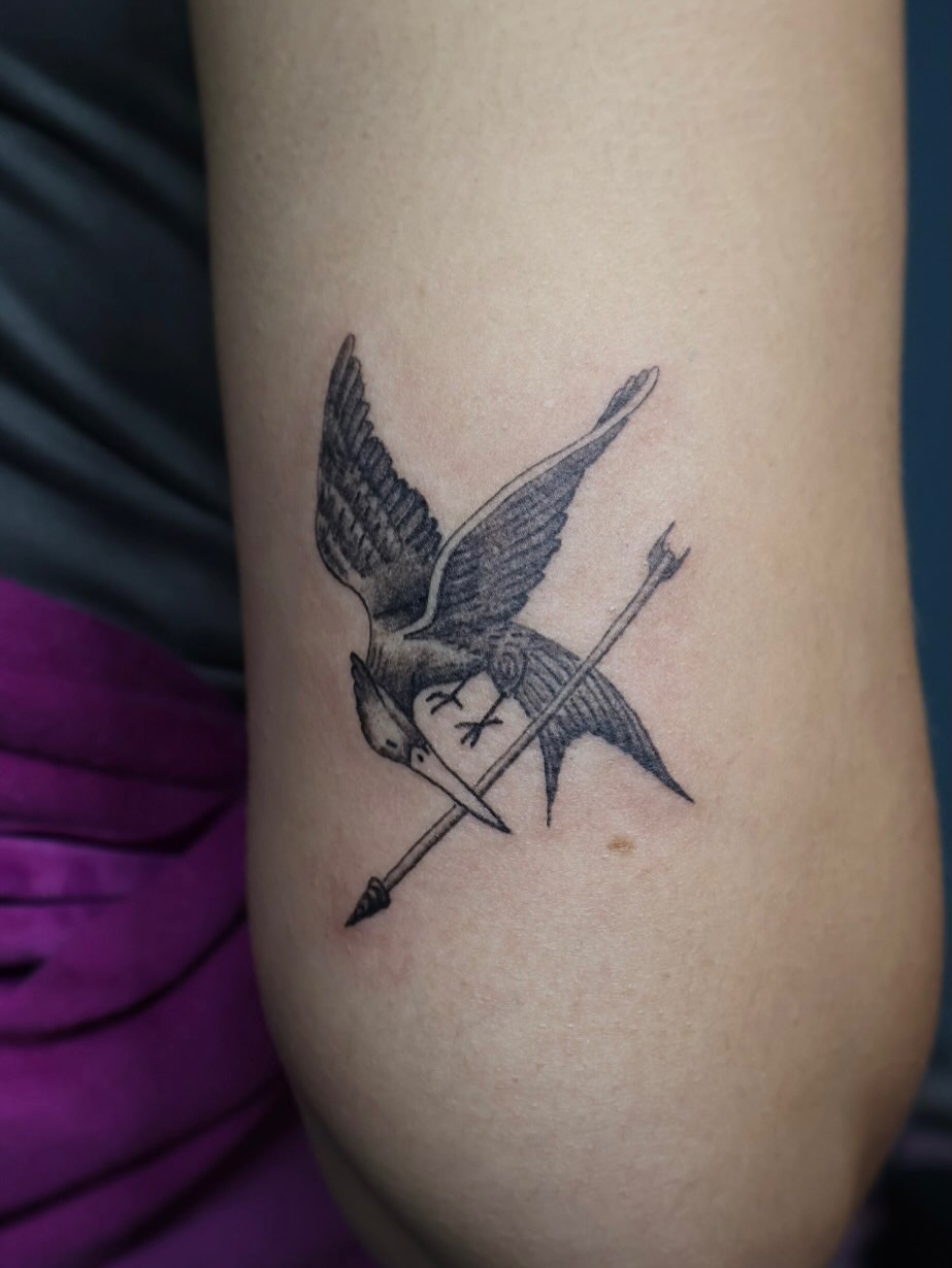 Bird with spear black and grey tattoo on the forearm by ππππππ