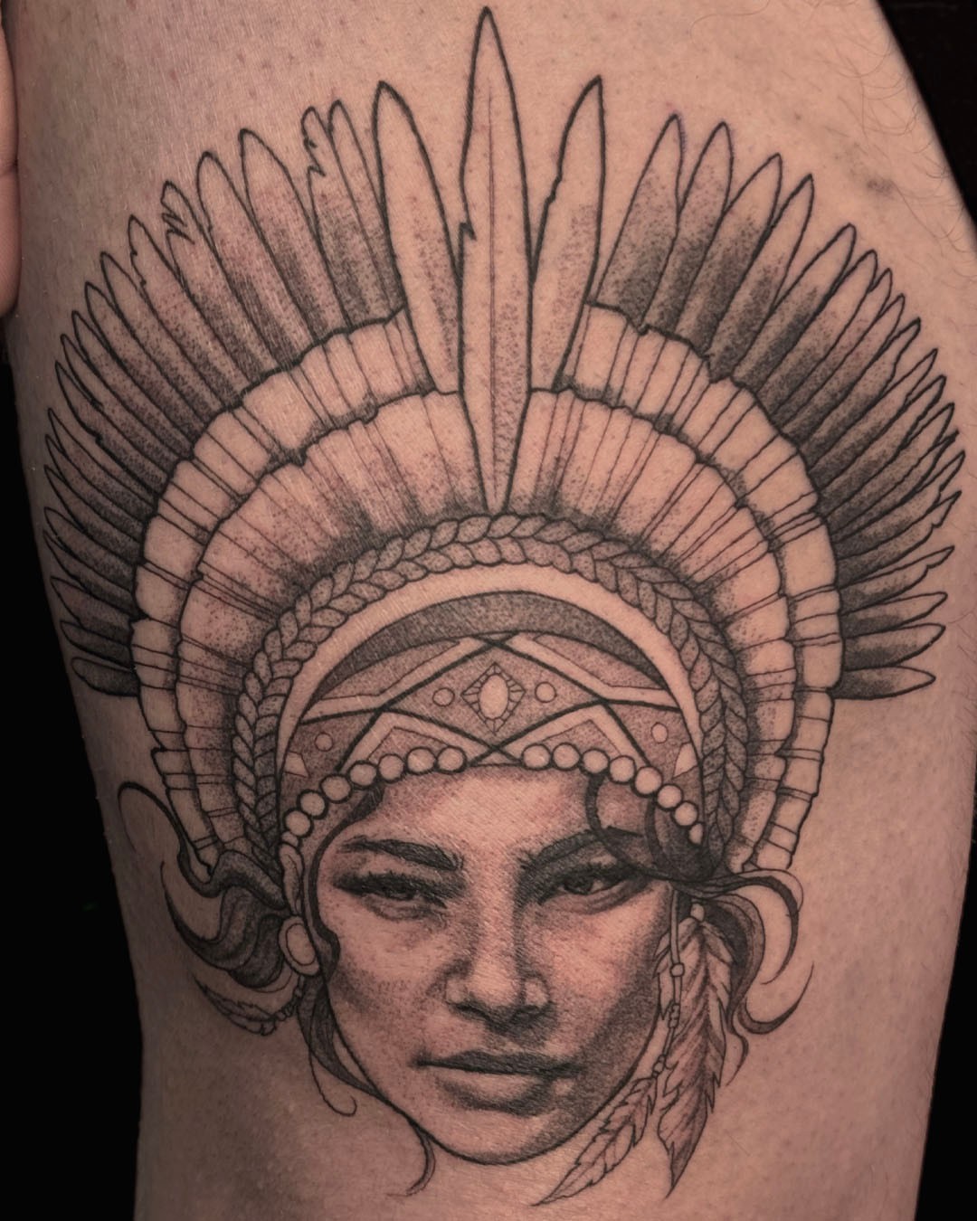Indian headdress realism tattoo on the thigh by Erin Isaacs