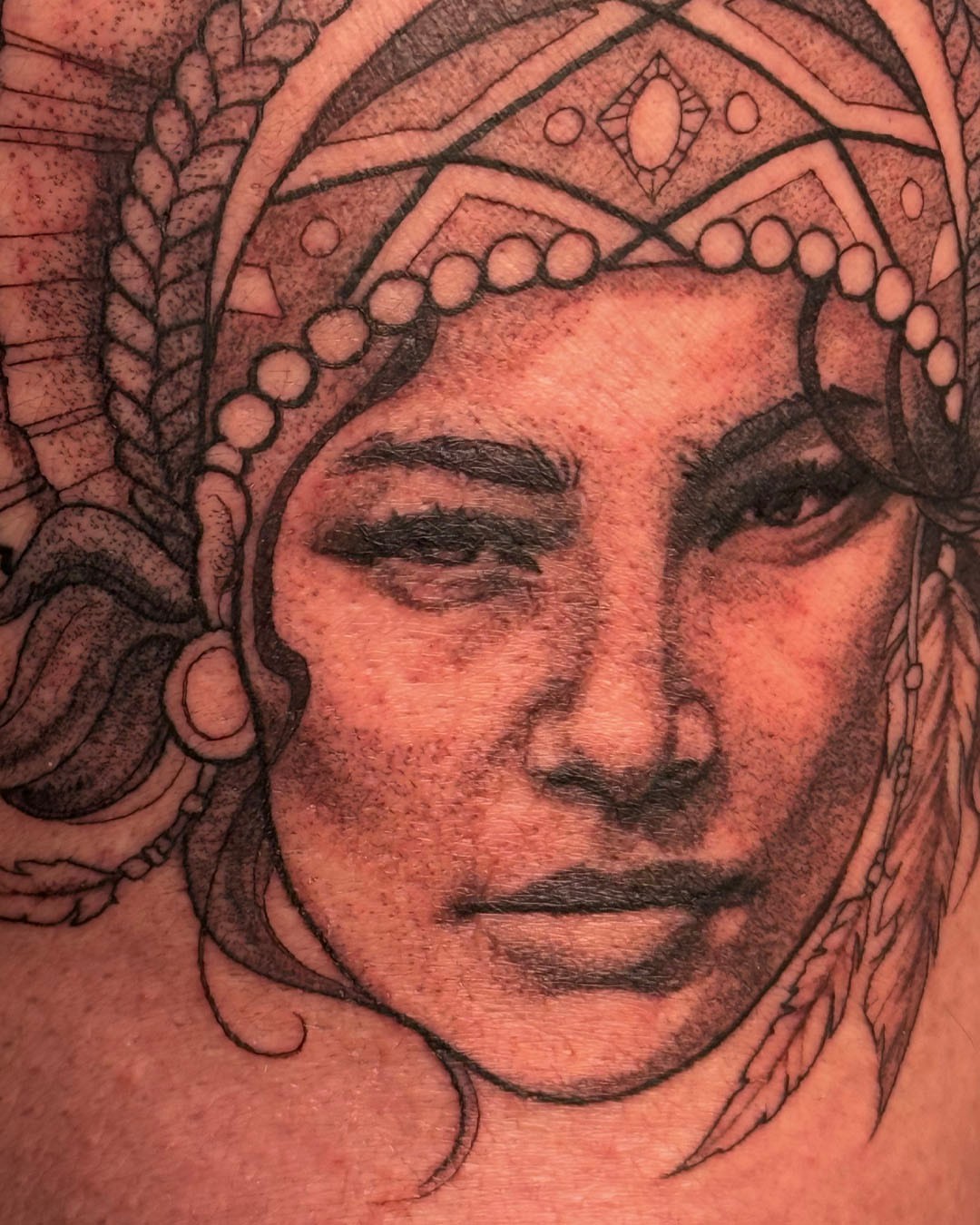 Woman's face realism tattoo on the shoulder by Erin Isaacs