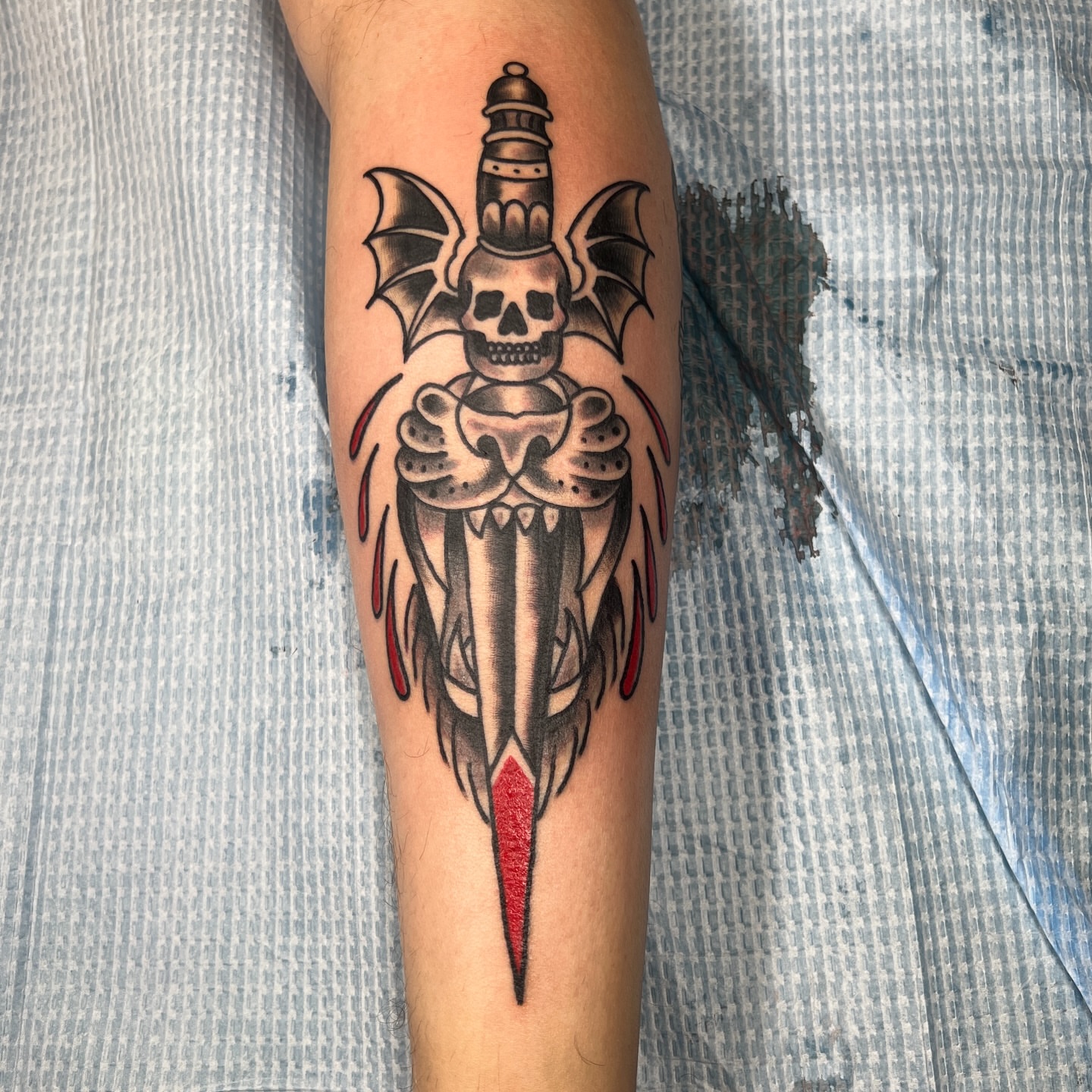 Skull and dagger American traditional tattoo on the forearm by Brian Mock