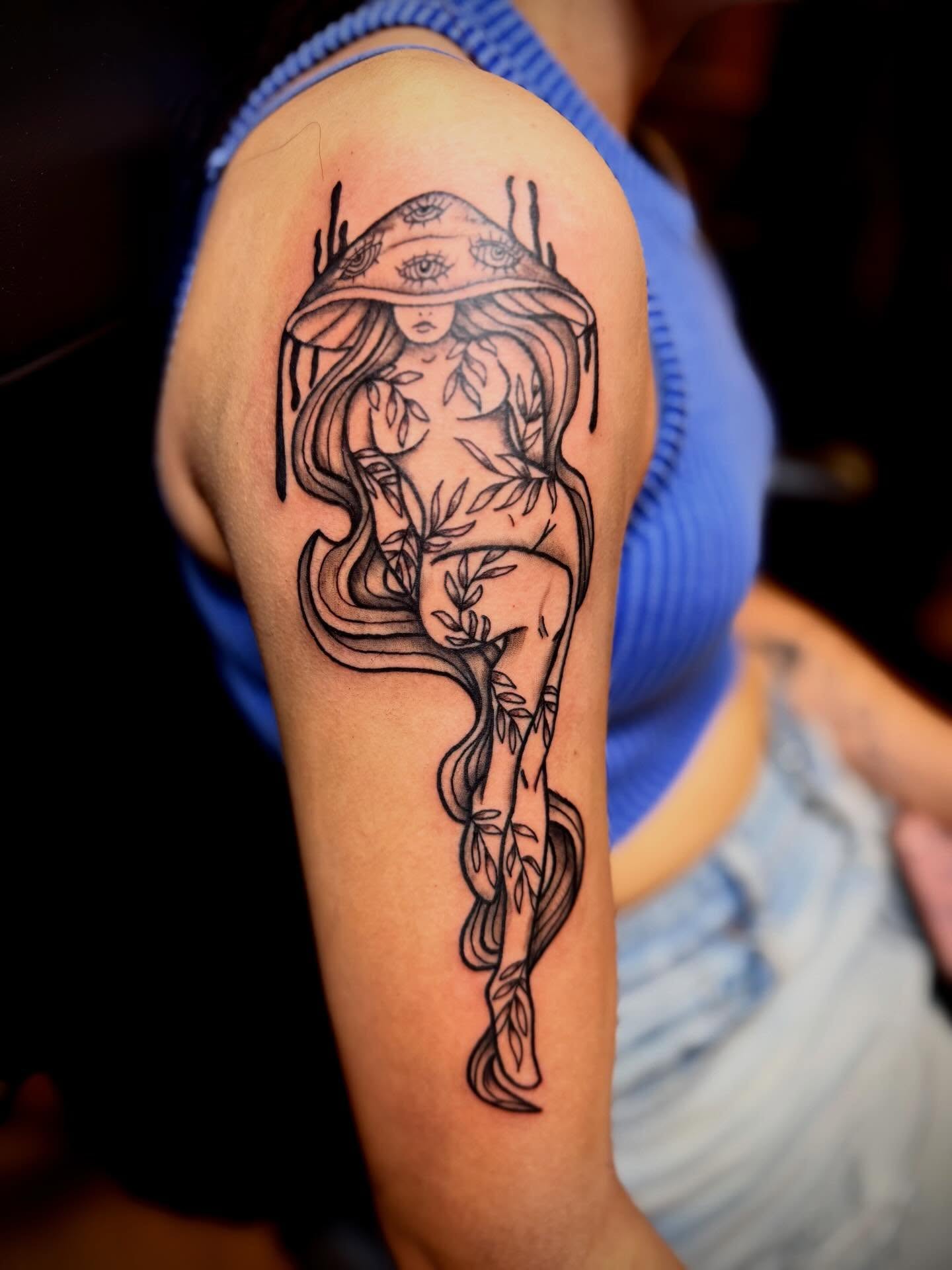 Woman with hat black and grey tattoo on the upper arm by Joshua Ware, Alvarado, Texas