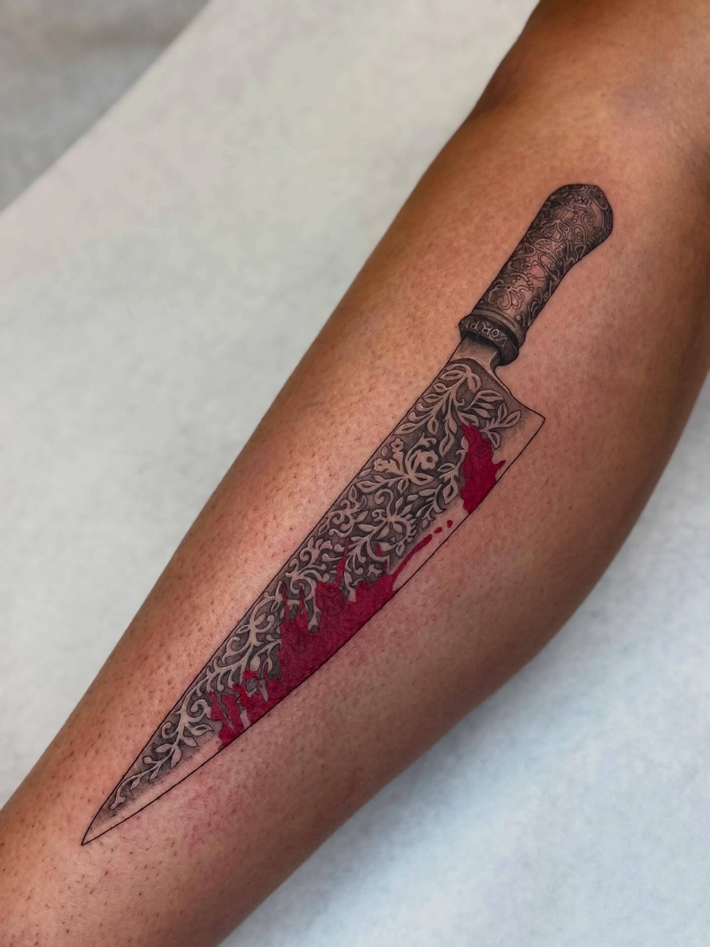 Knife realism tattoo on the forearm by Em Krieg
