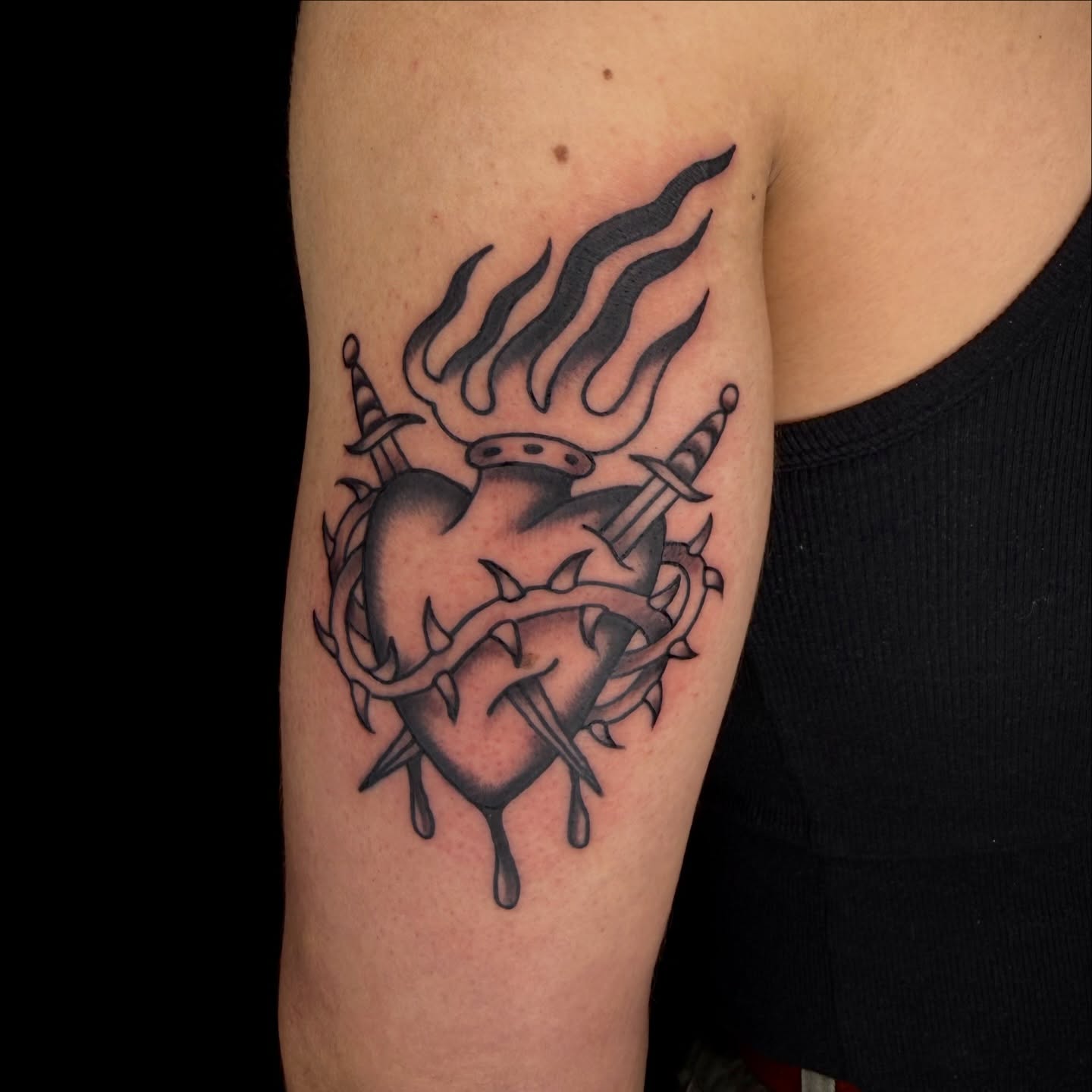 Heart with flames and swords dark realism tattoo on the forearm by Kaysen
