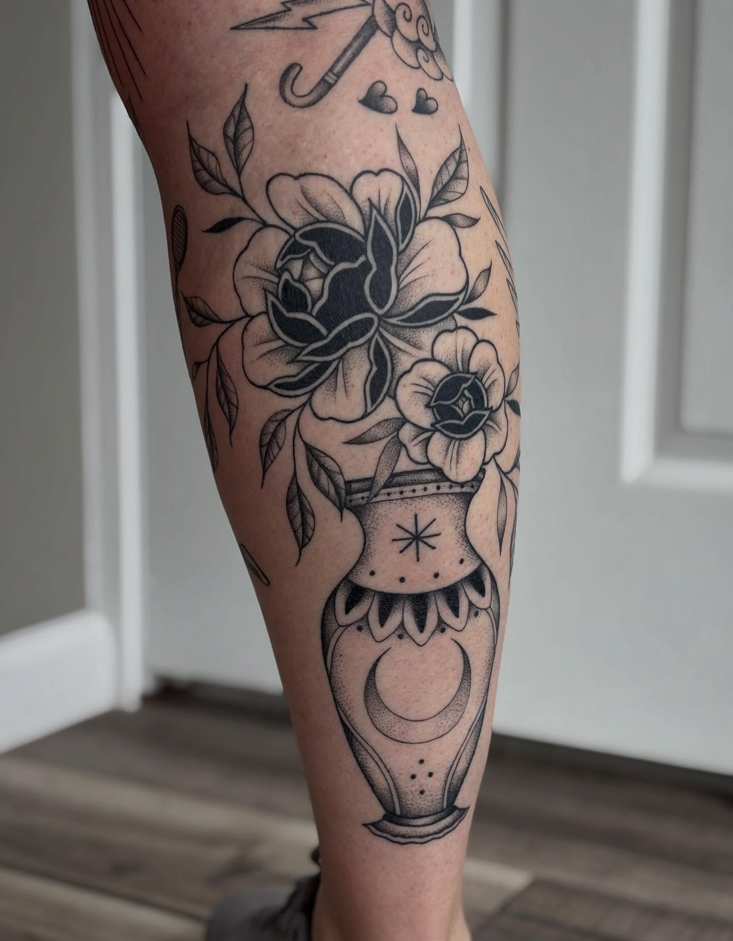 Hourglass and flowers black and grey tattoo on the calf by Hailey Nicole