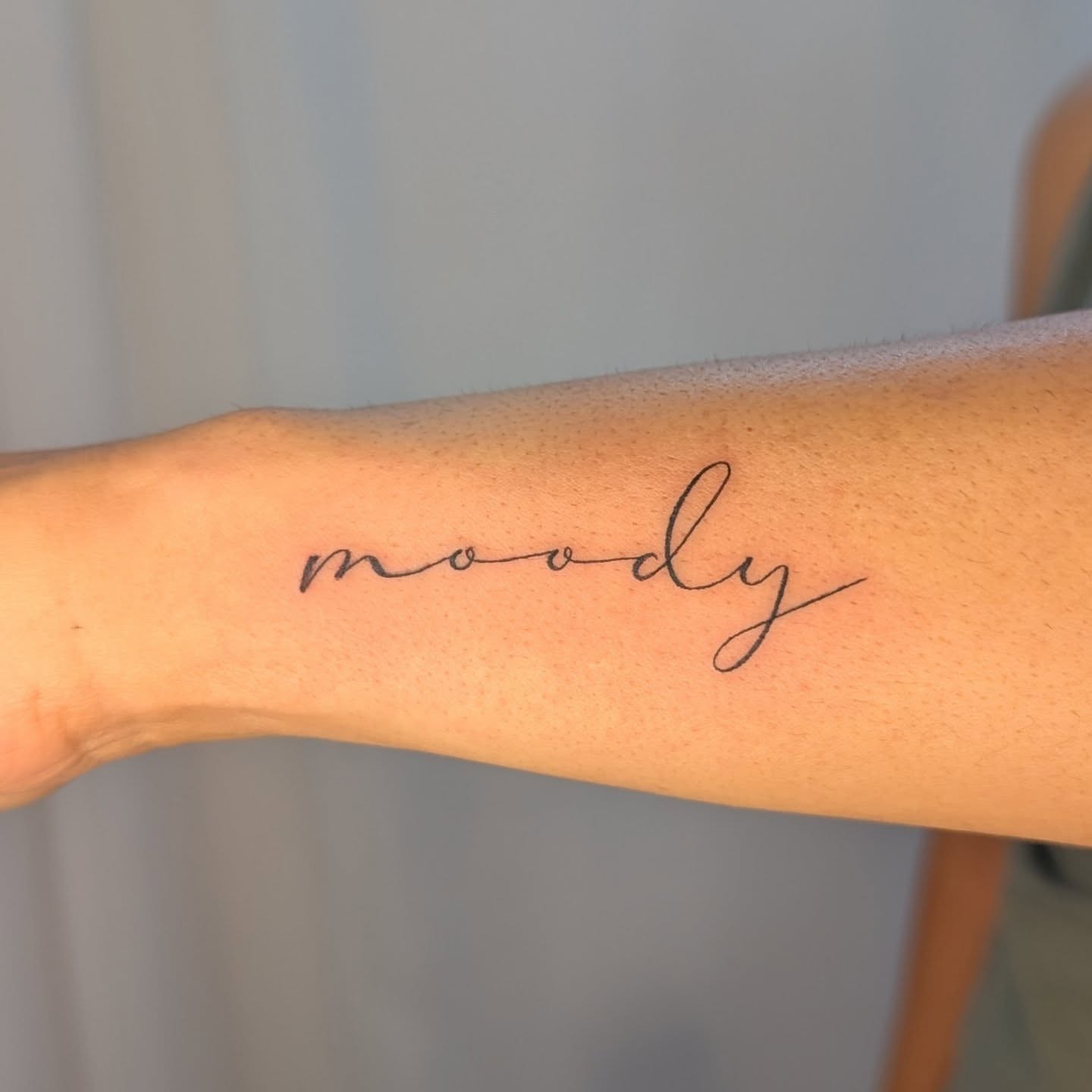 Moody lettering script tattoo on the forearm by Nenookaasi Martin