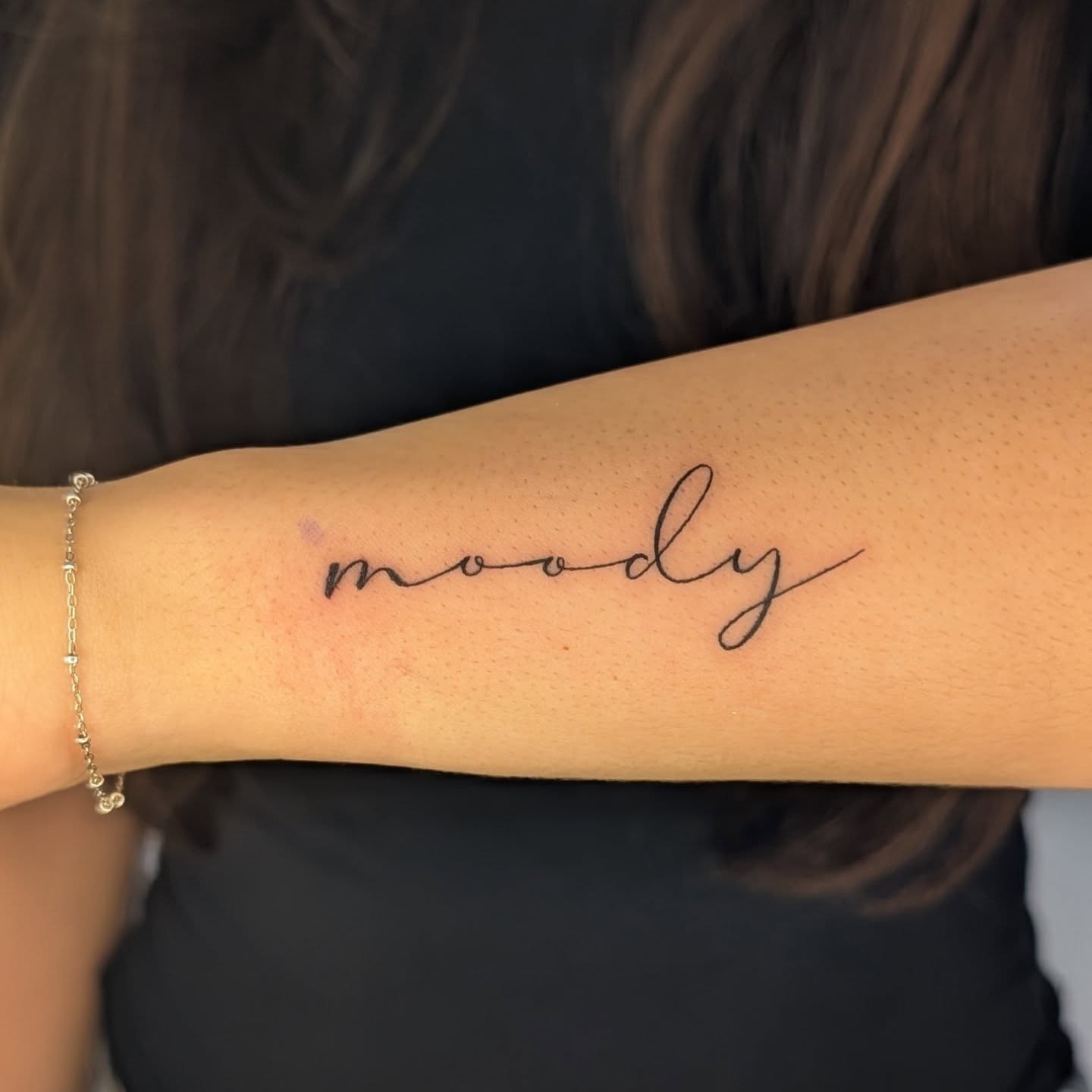Moody lettering script tattoo on the forearm by Nenookaasi Martin