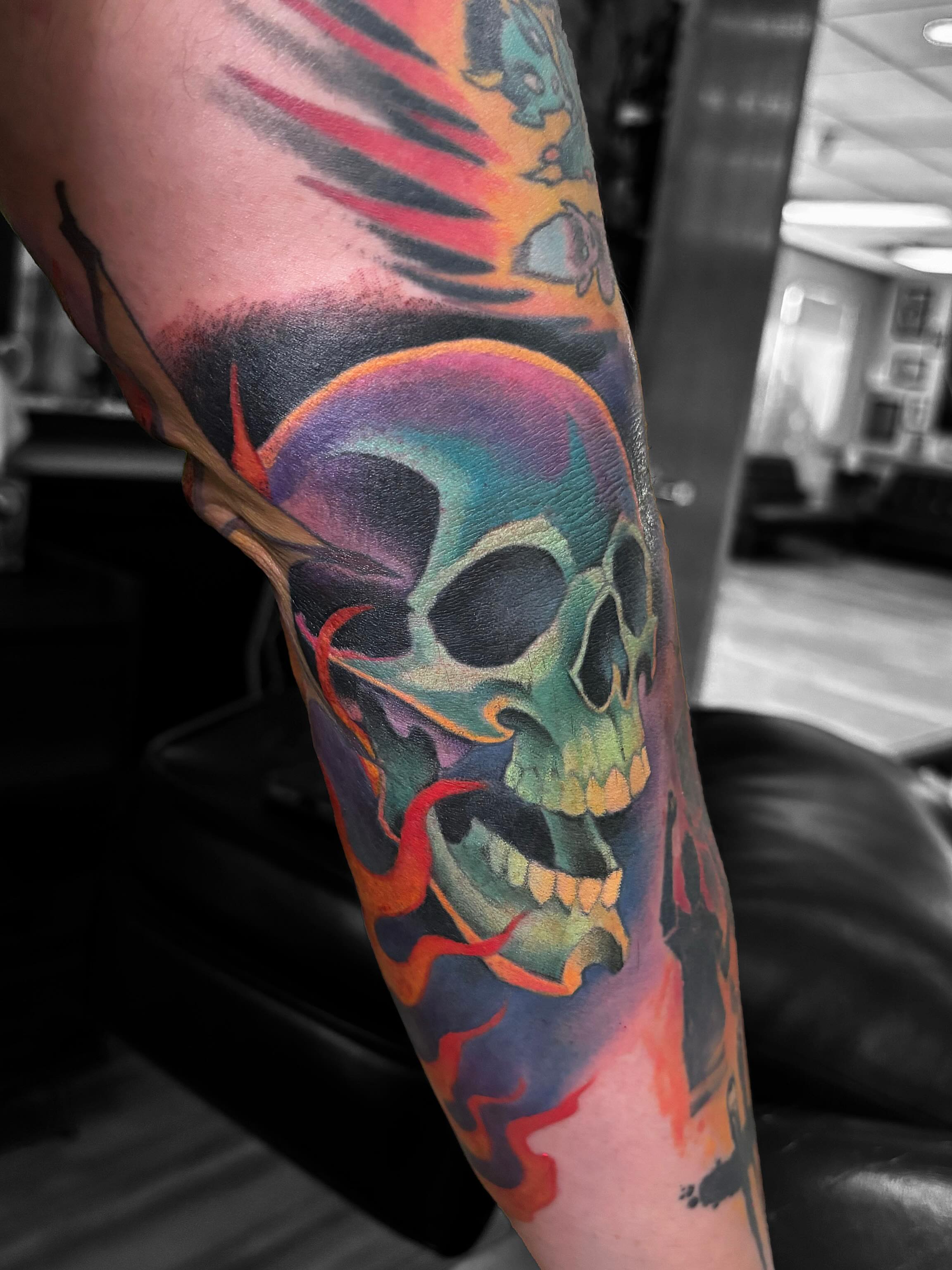 Skull with flames new school tattoo on the forearm by Alex