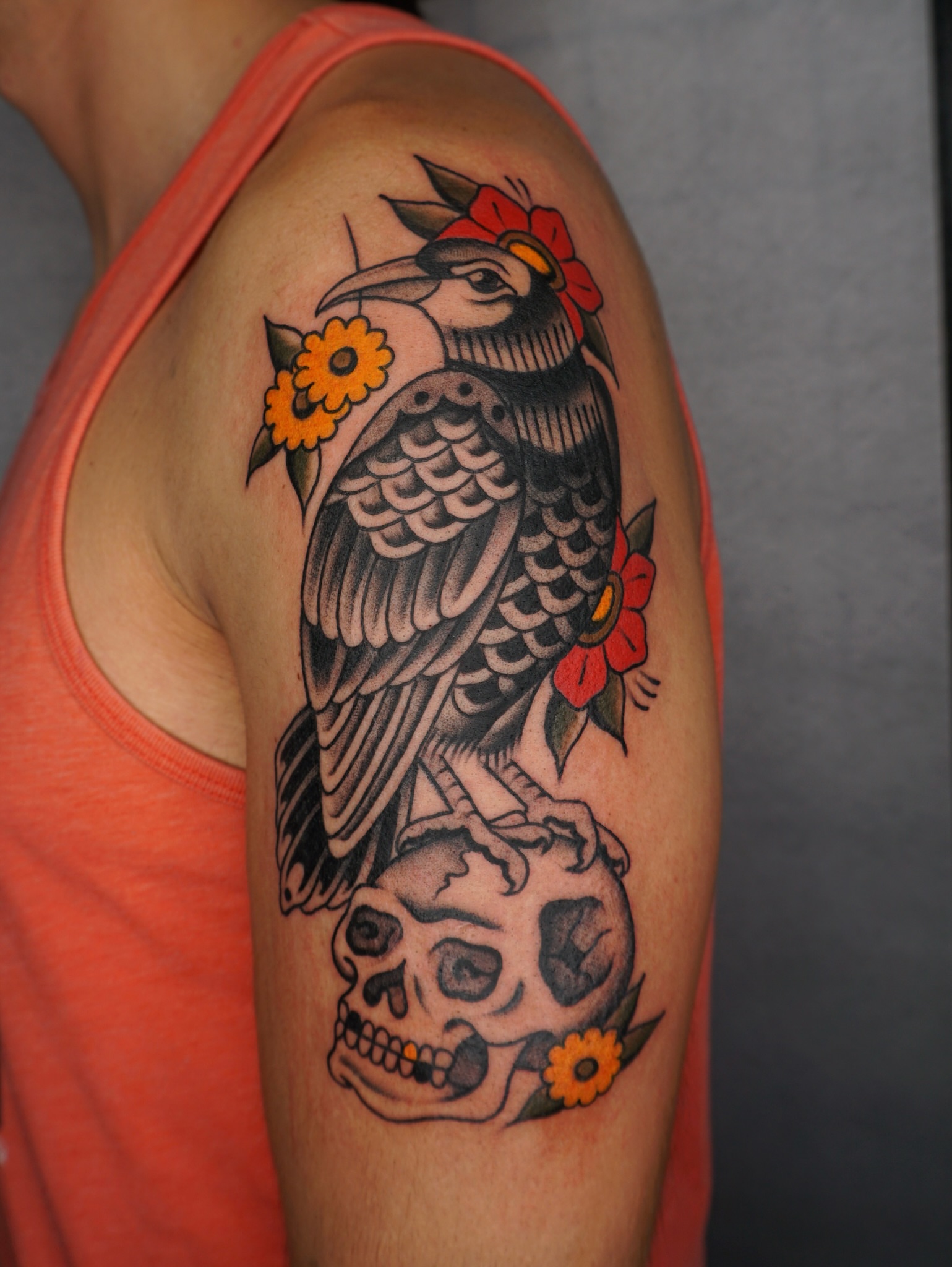 Bird and skull American traditional tattoo on the upper arm by Sarah Christine Tattoo, Calgary, Alberta