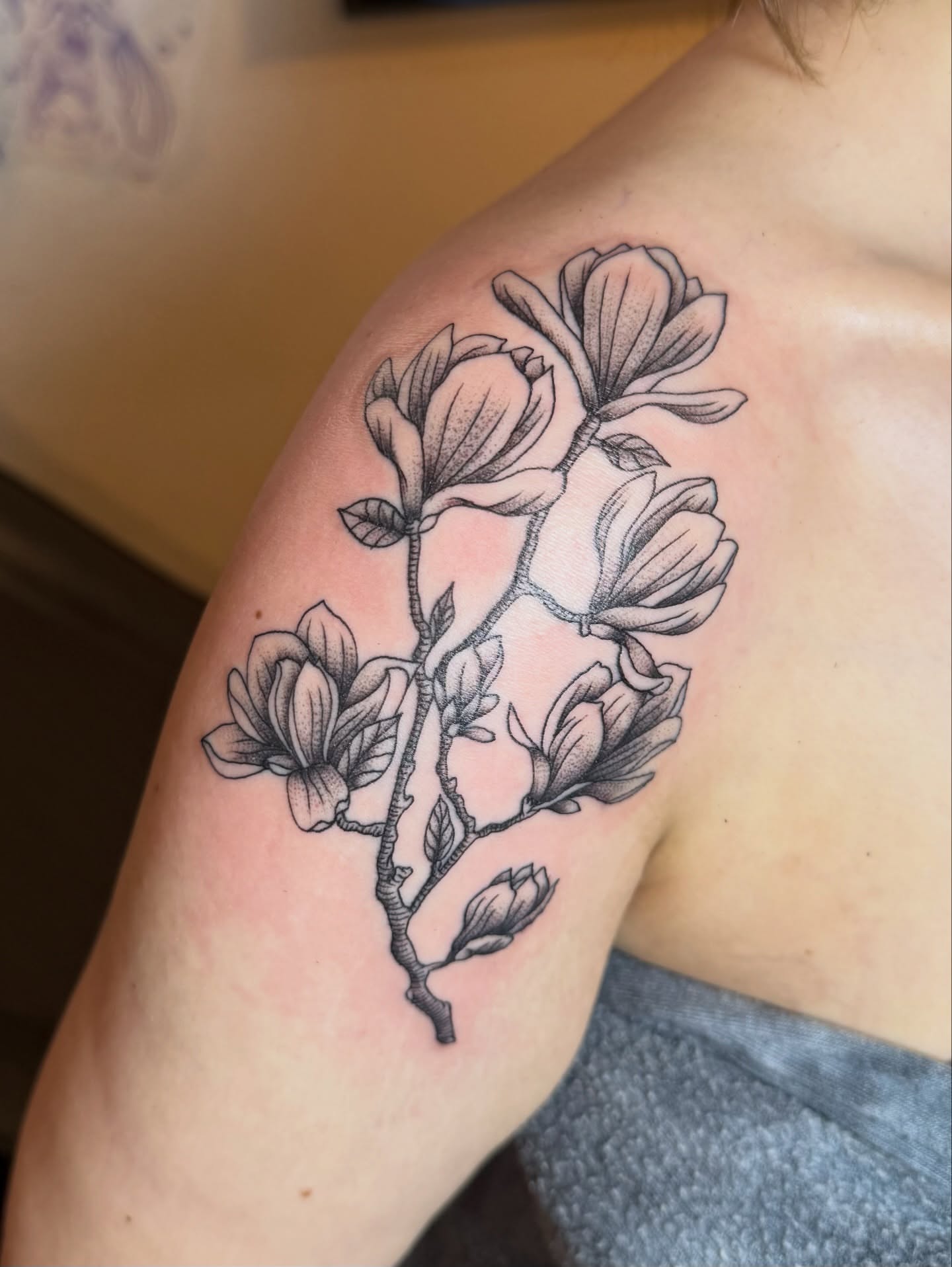 Magnolia blossoms black and grey tattoo on the shoulder by Jenna Nicole