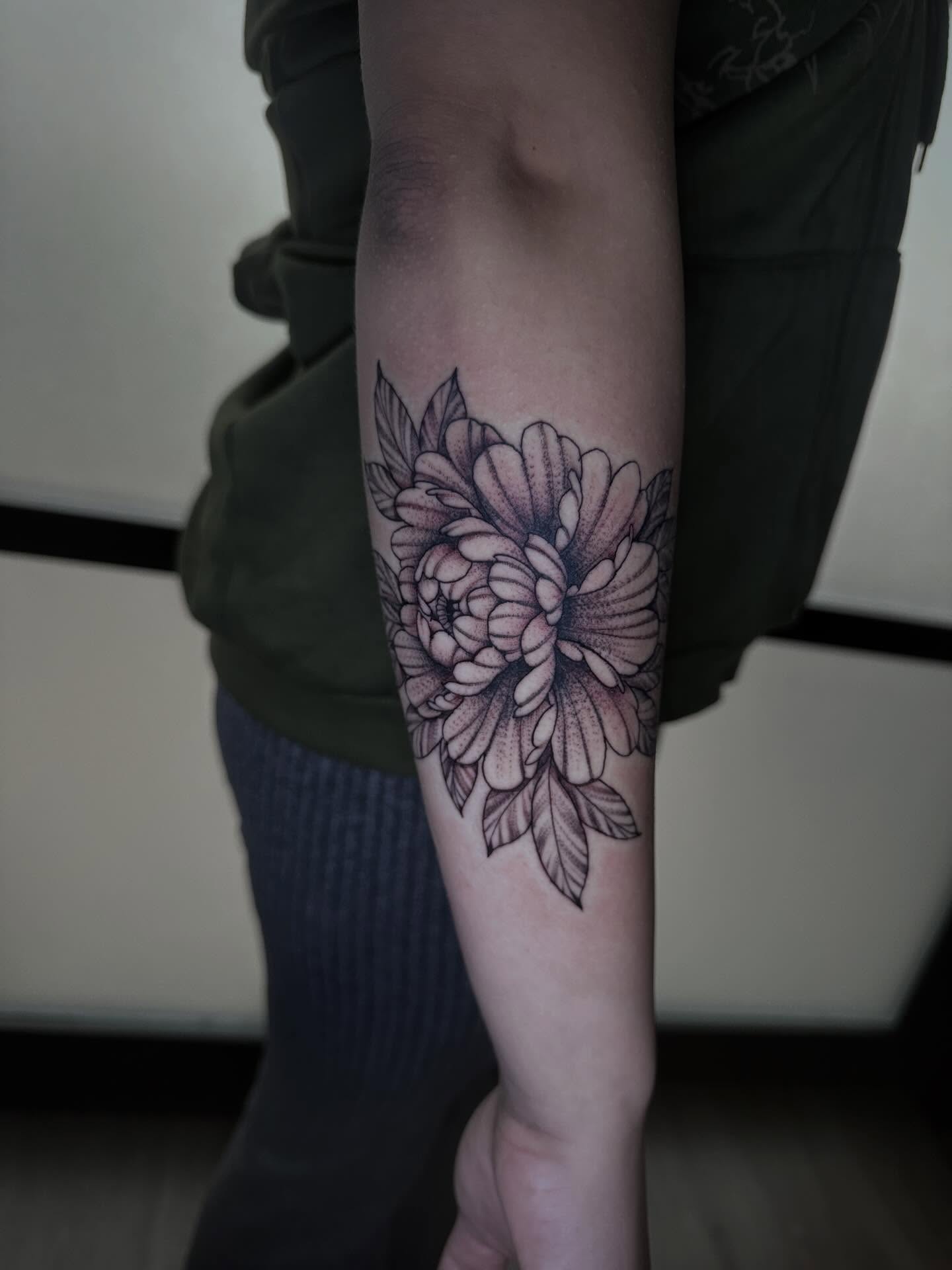 Chrysanthemum black and grey tattoo on the forearm by Sierra