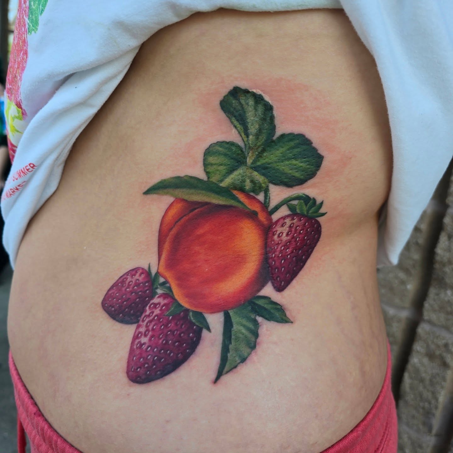 Peach and strawberries realism tattoo on the ribs by Gabrielle Nicole Soucie