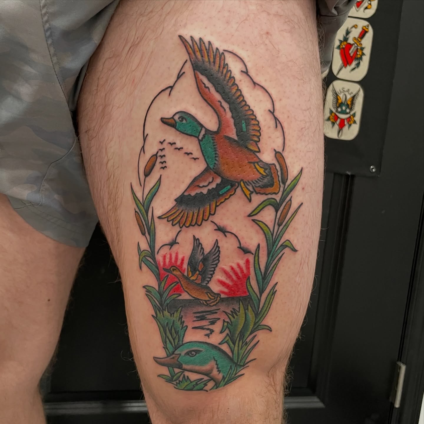 Ducks and foliage American traditional tattoo on the thigh by Greg De Hoot, Youngsville, North Carolina