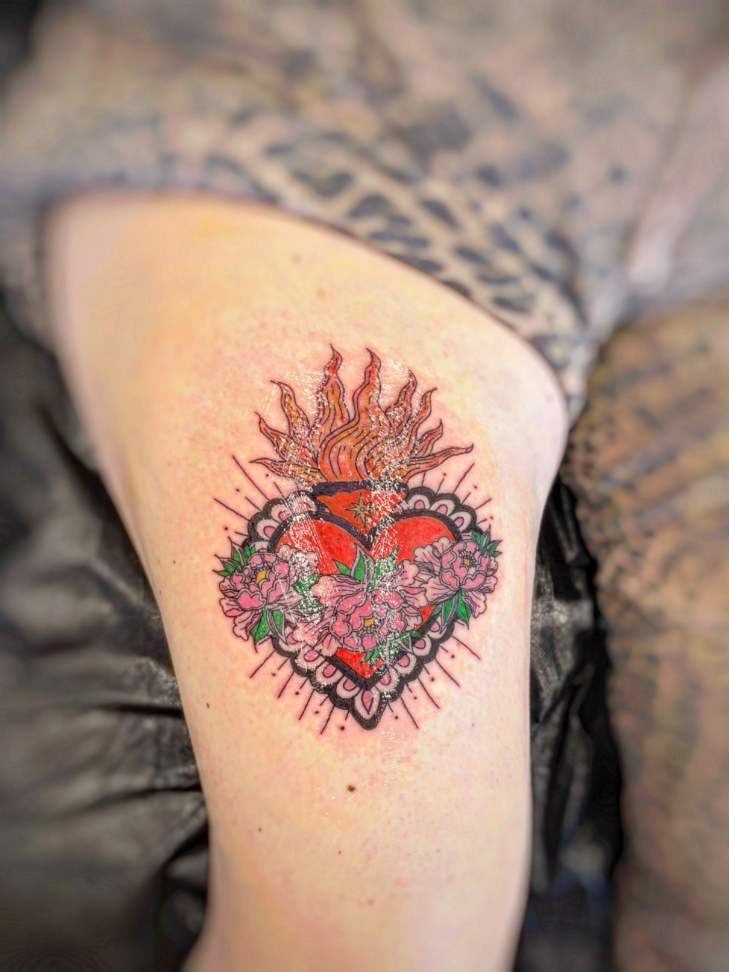 Floral heart American traditional tattoo on the thigh by Holly