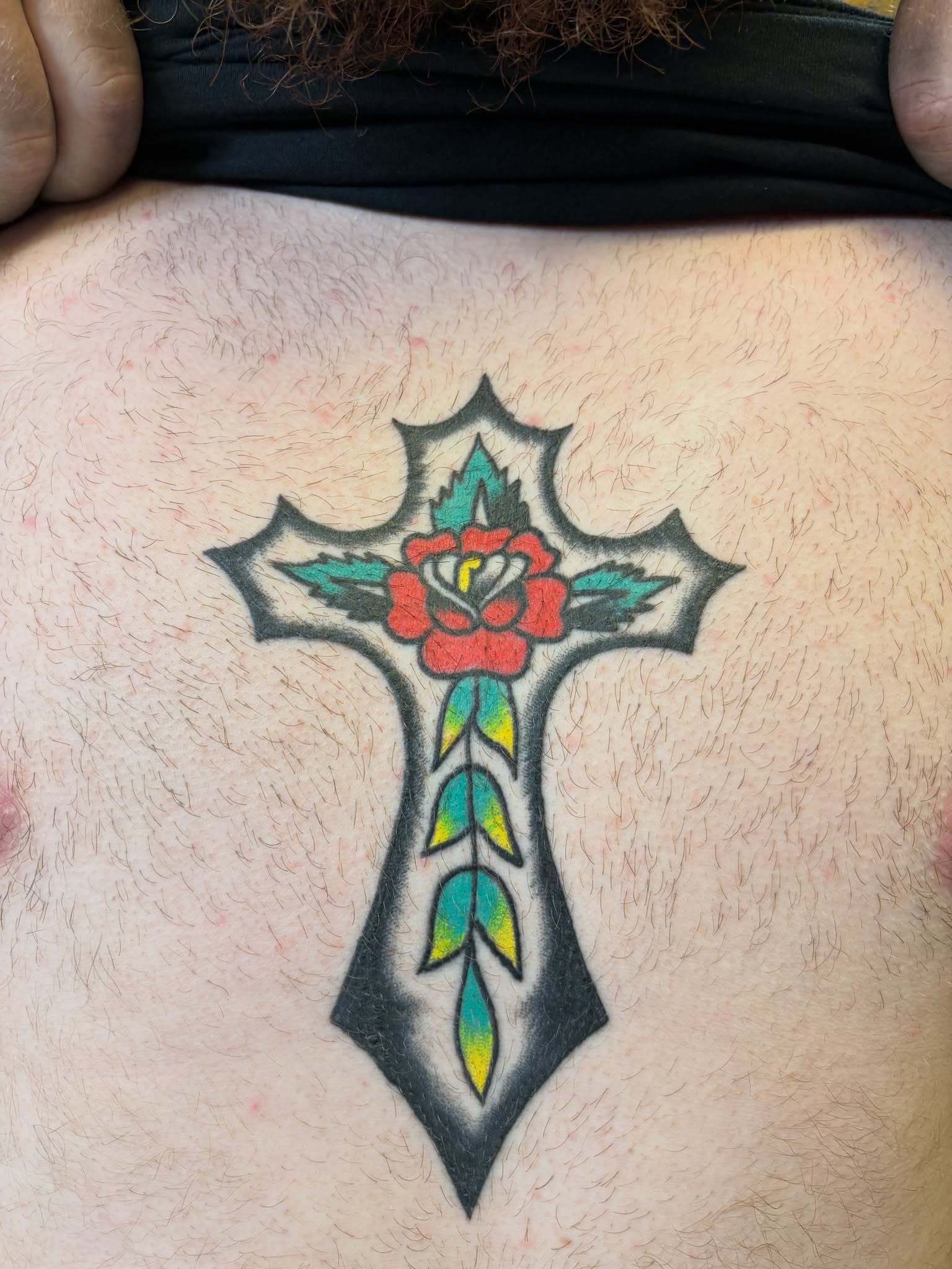 Cross with floral detail American traditional tattoo on the thigh by Cooper Reichwein