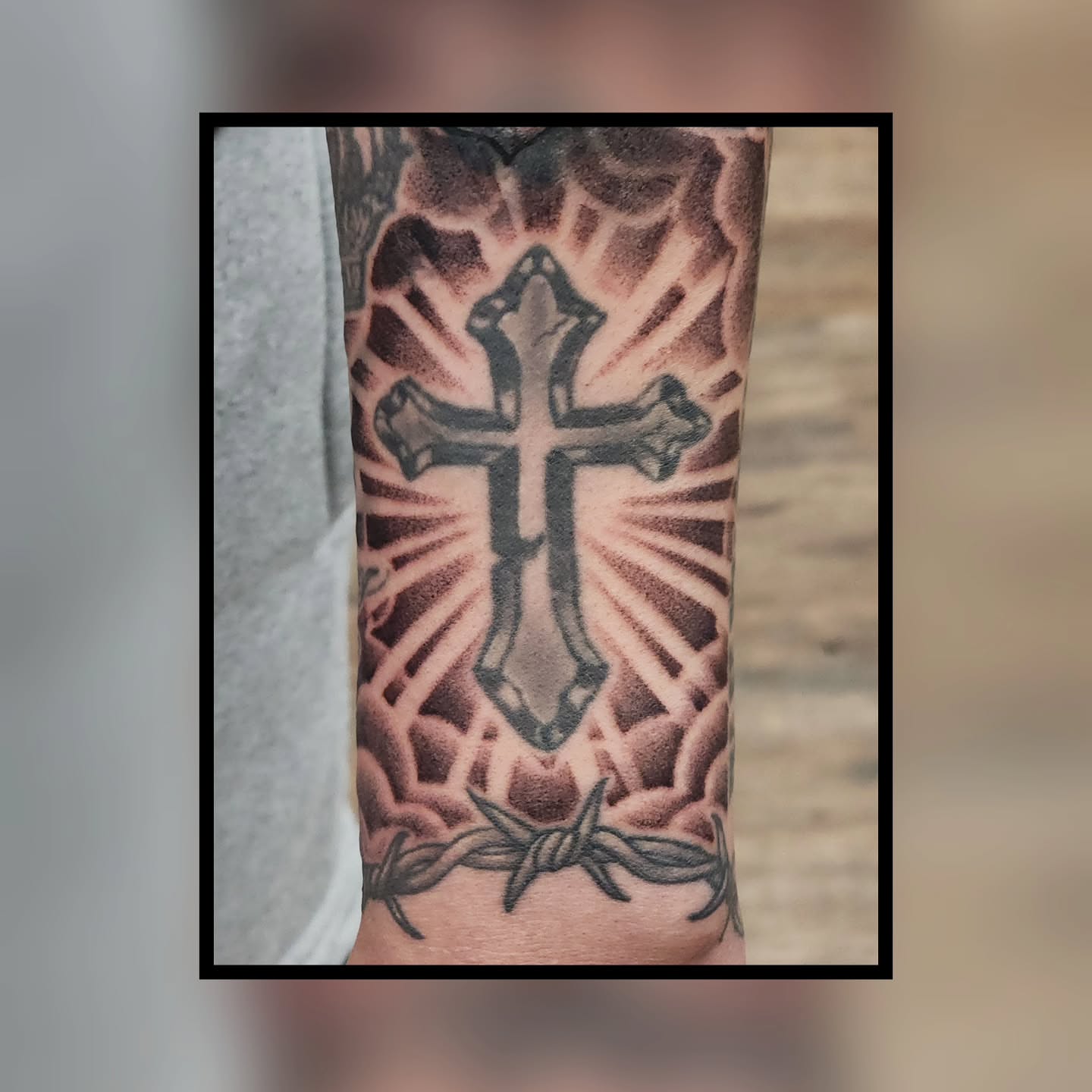 Cross with barbed wire black and grey tattoo on the forearm by Trista Bettfreund (Birdy)