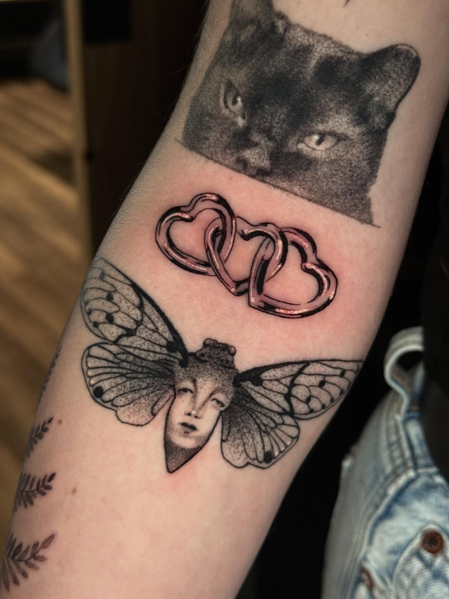 Cat and hearts dotwork tattoo on the forearm by Mads Ink