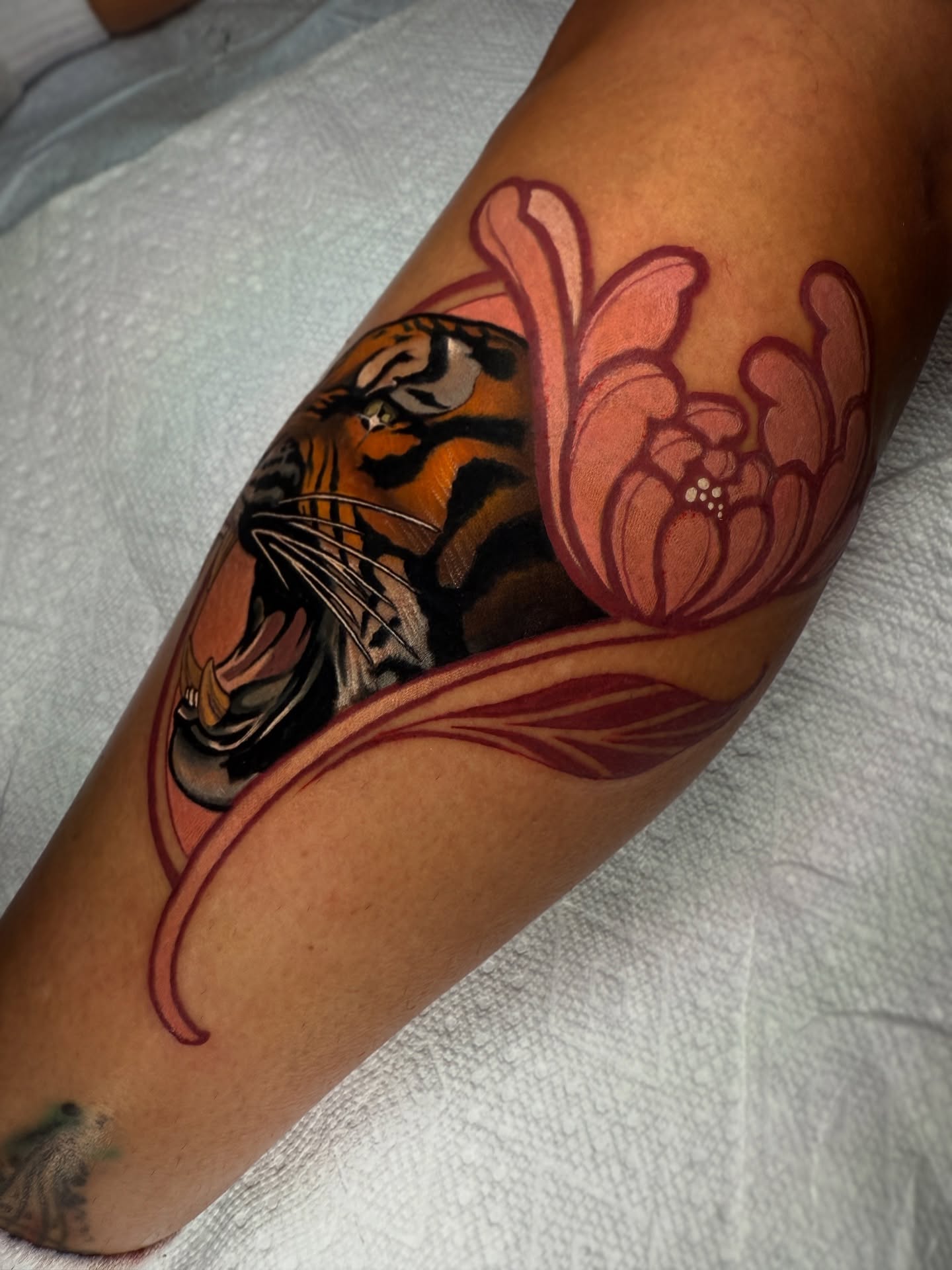 Tiger and flower American traditional tattoo on the forearm by Neotrav Tattoos