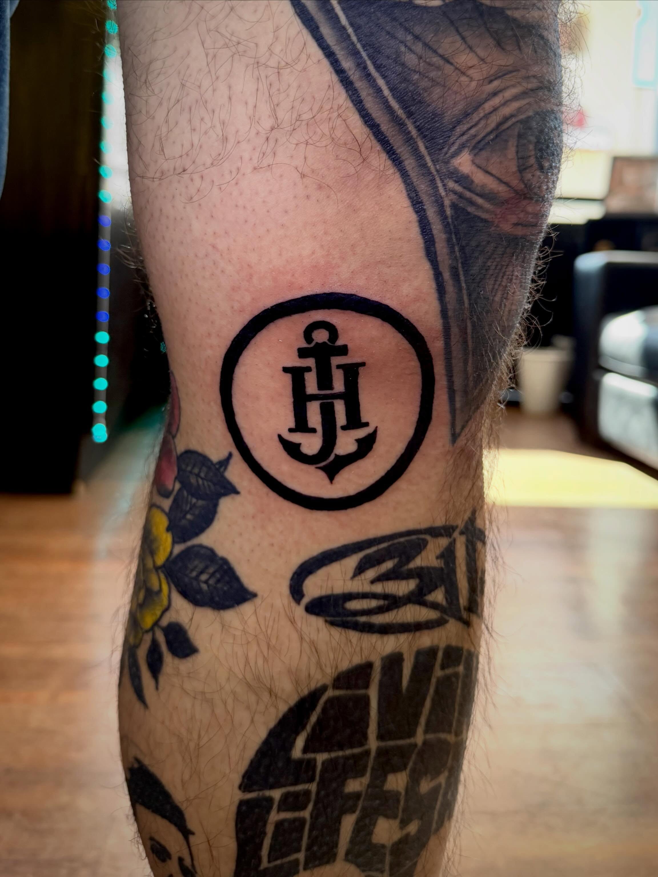 Anchor and initials black and grey tattoo on the forearm by Mikey