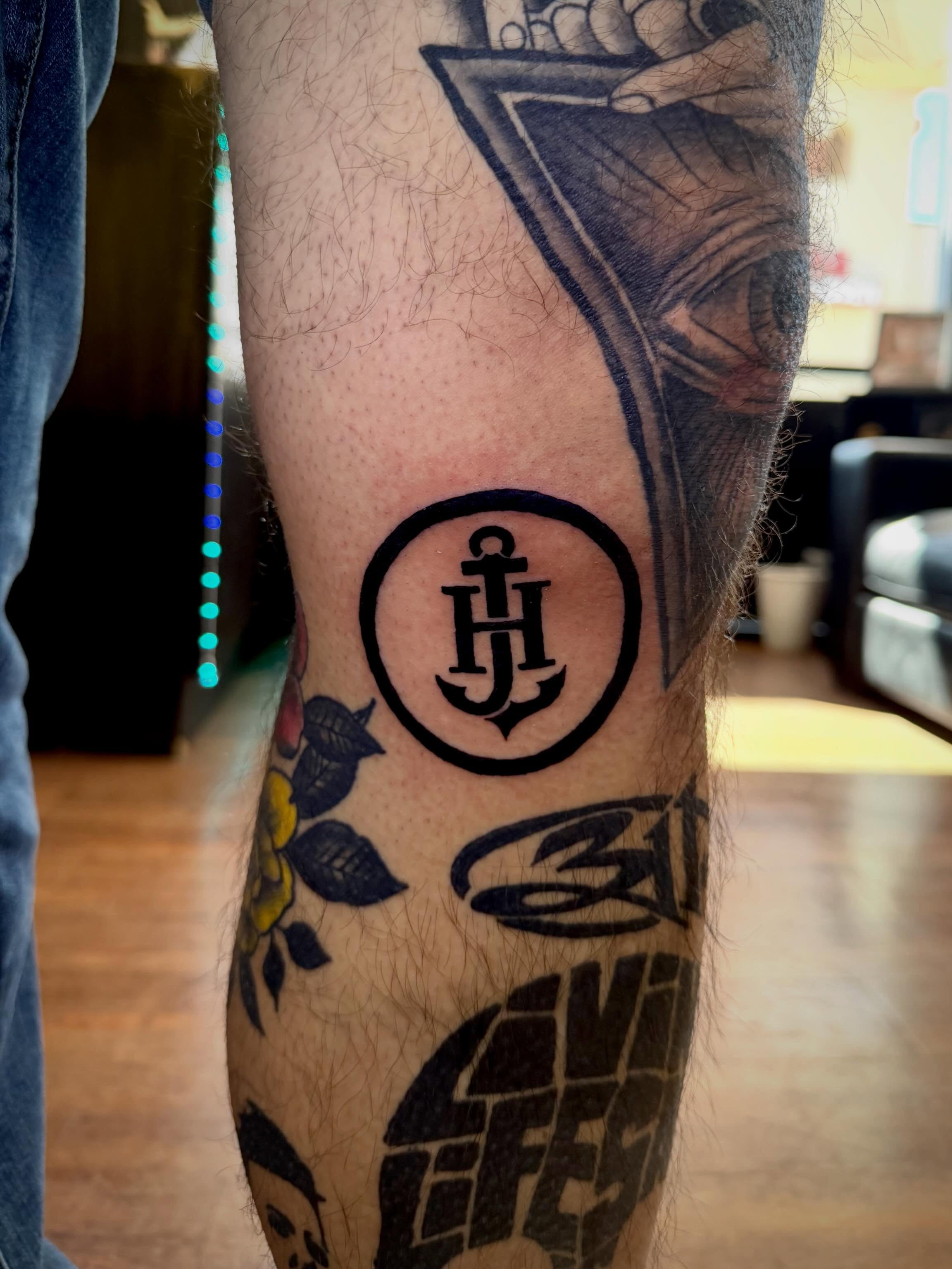 Anchor and initials black and grey tattoo on the forearm by Mikey