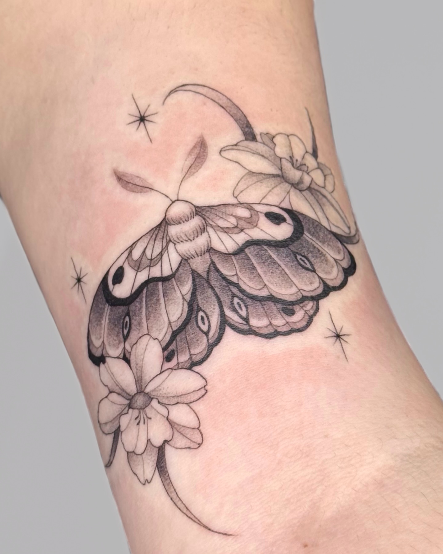 Butterfly and flowers realism tattoo on the forearm by Suzy