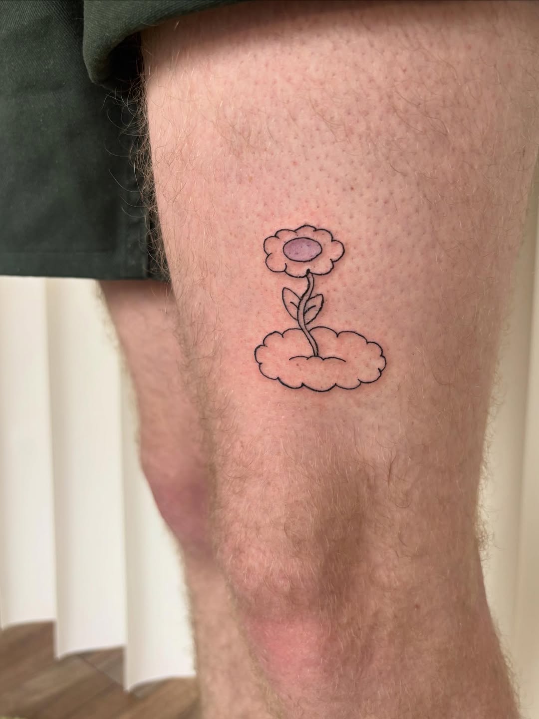 Flower on a cloud ignorant tattoo on the thigh by riley
