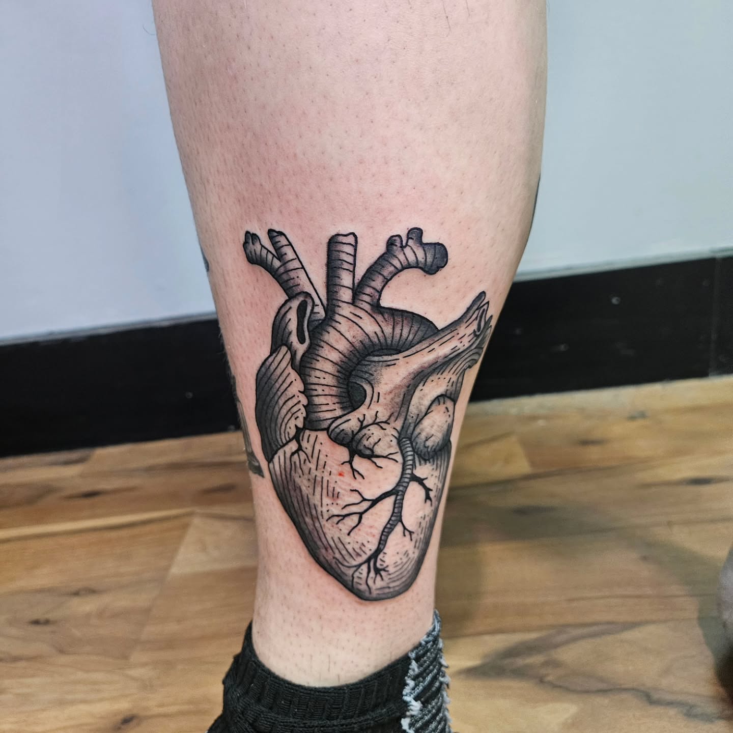 Anatomical heart black and grey tattoo on the calf by Danny