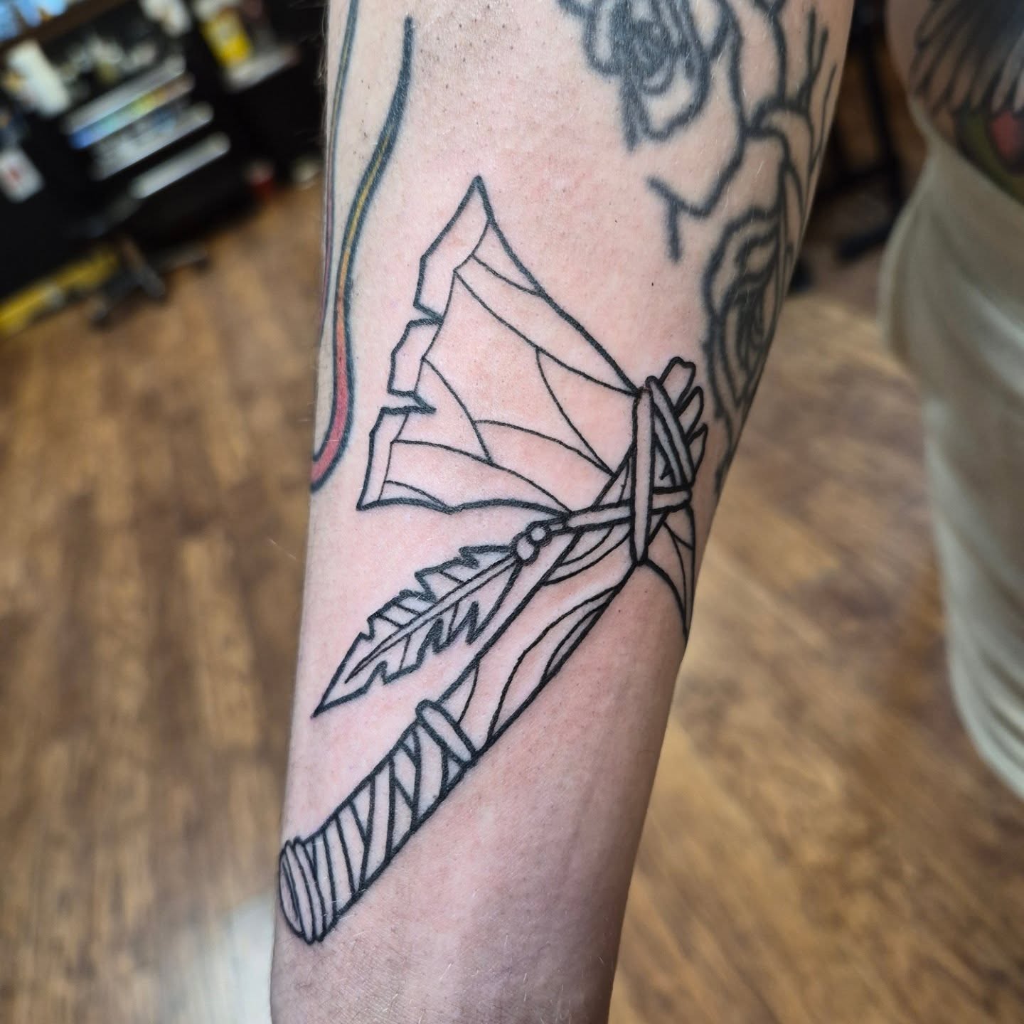 Arrow with feather geometric tattoo on the forearm by Bobby H
