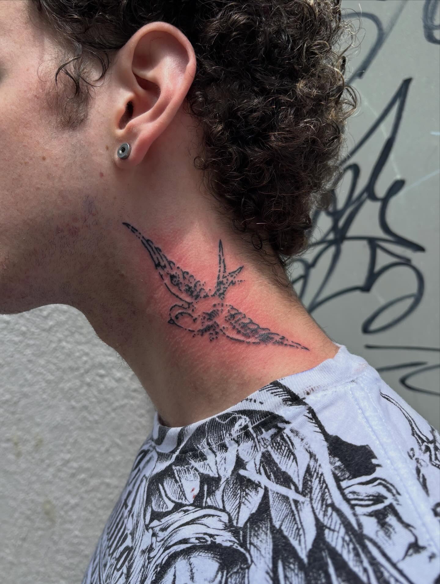 Bird black and grey tattoo on the neck by Turner