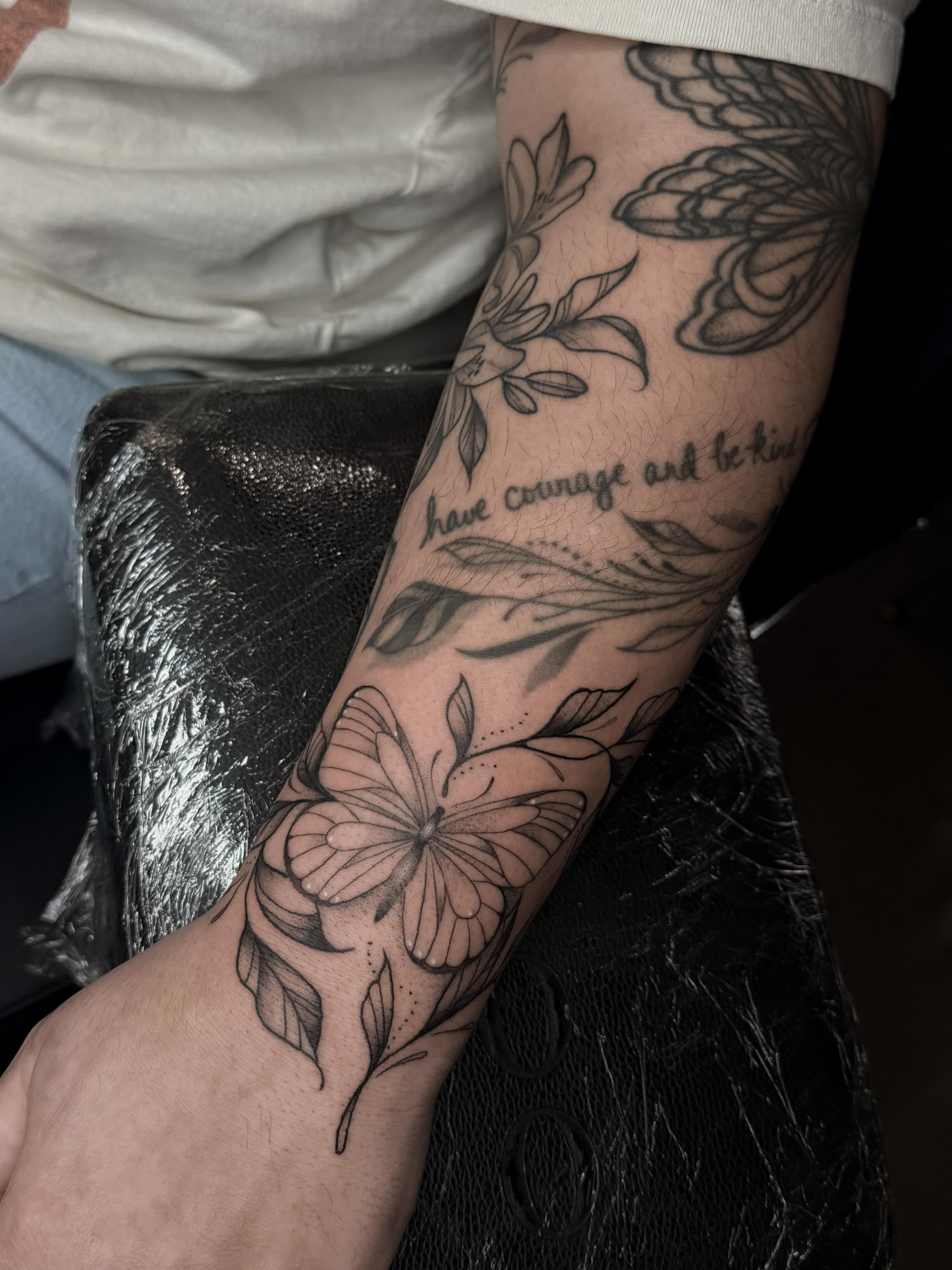 Butterfly and floral black and grey tattoo on the forearm by Susie Maj