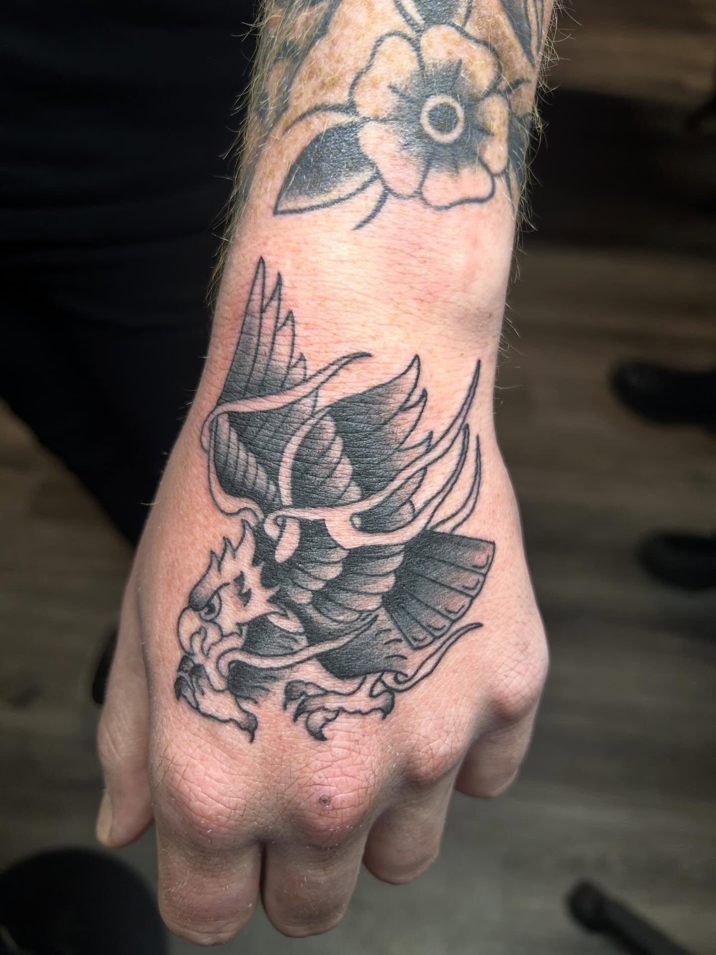 Dragon American traditional tattoo on the hand by Zach Andrews