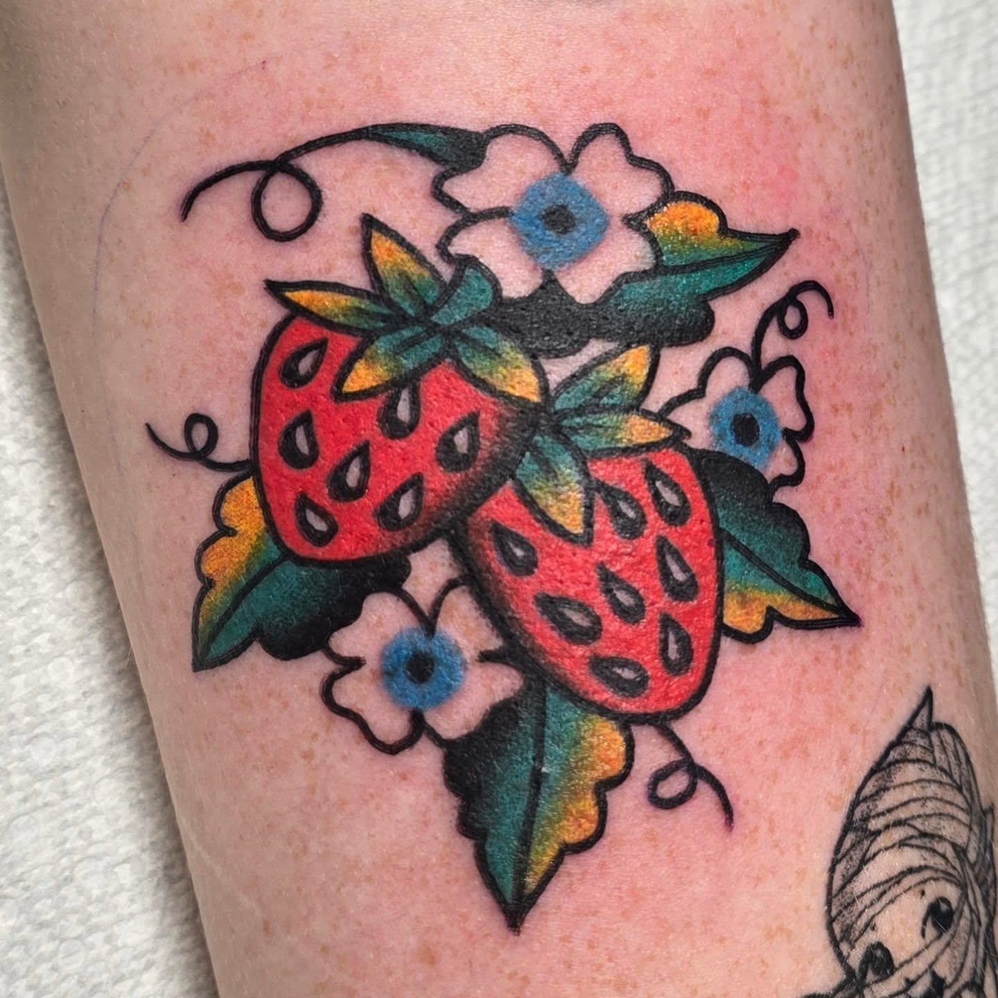Strawberries and flowers American traditional tattoo on the forearm by A. Teixeira, Los Angeles, California