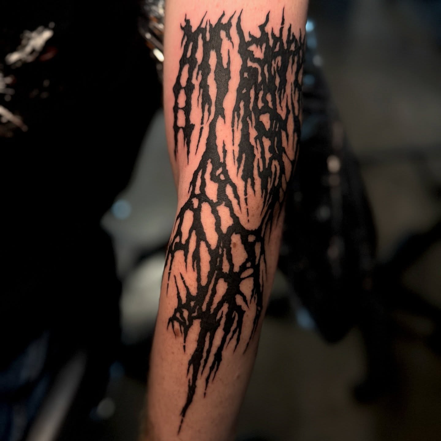 Abstract flame pattern blackwork tattoo on the forearm by Seth Christianson