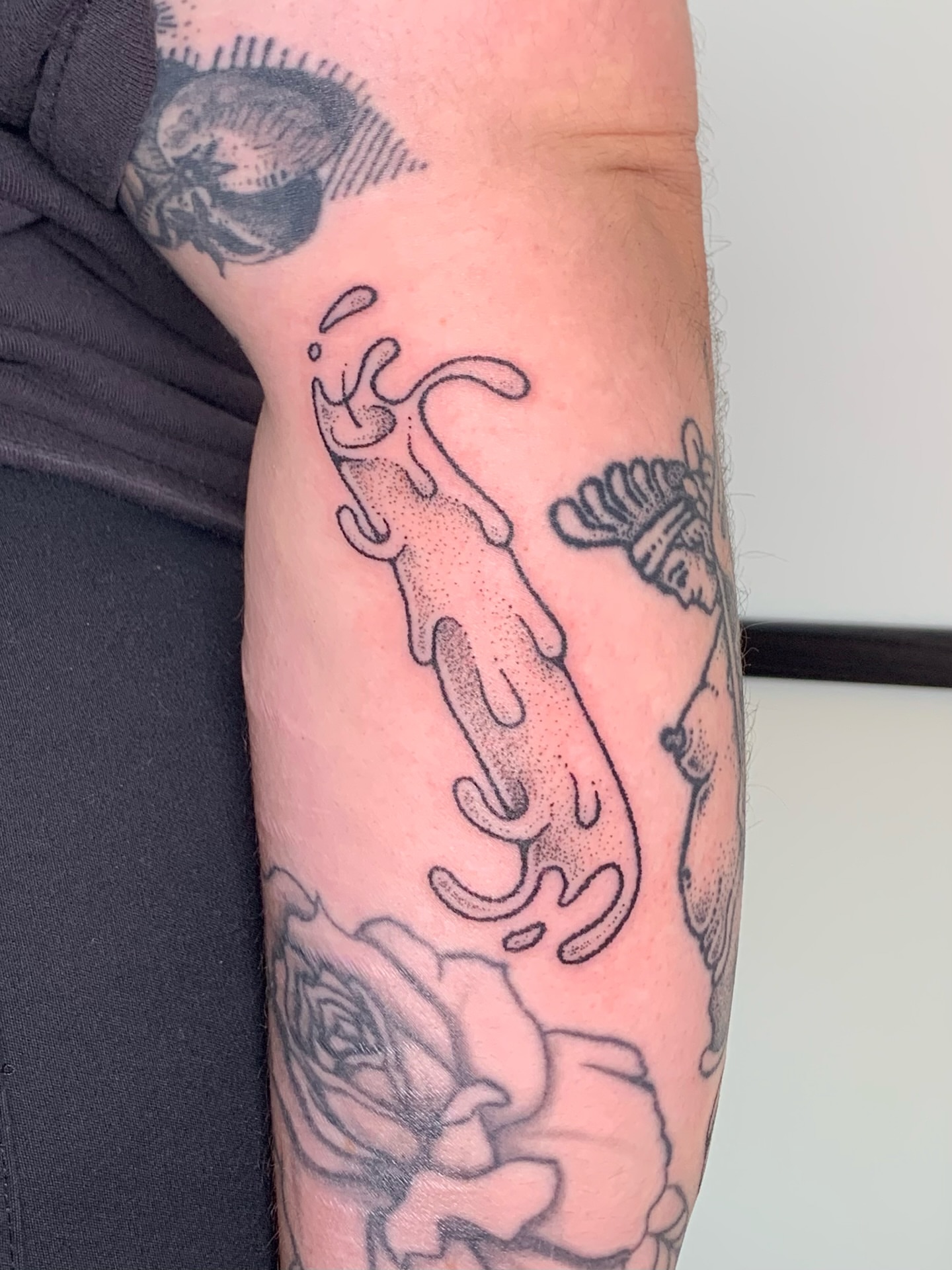 Abstract fluid dotwork tattoo on the forearm by Lex Lloyd