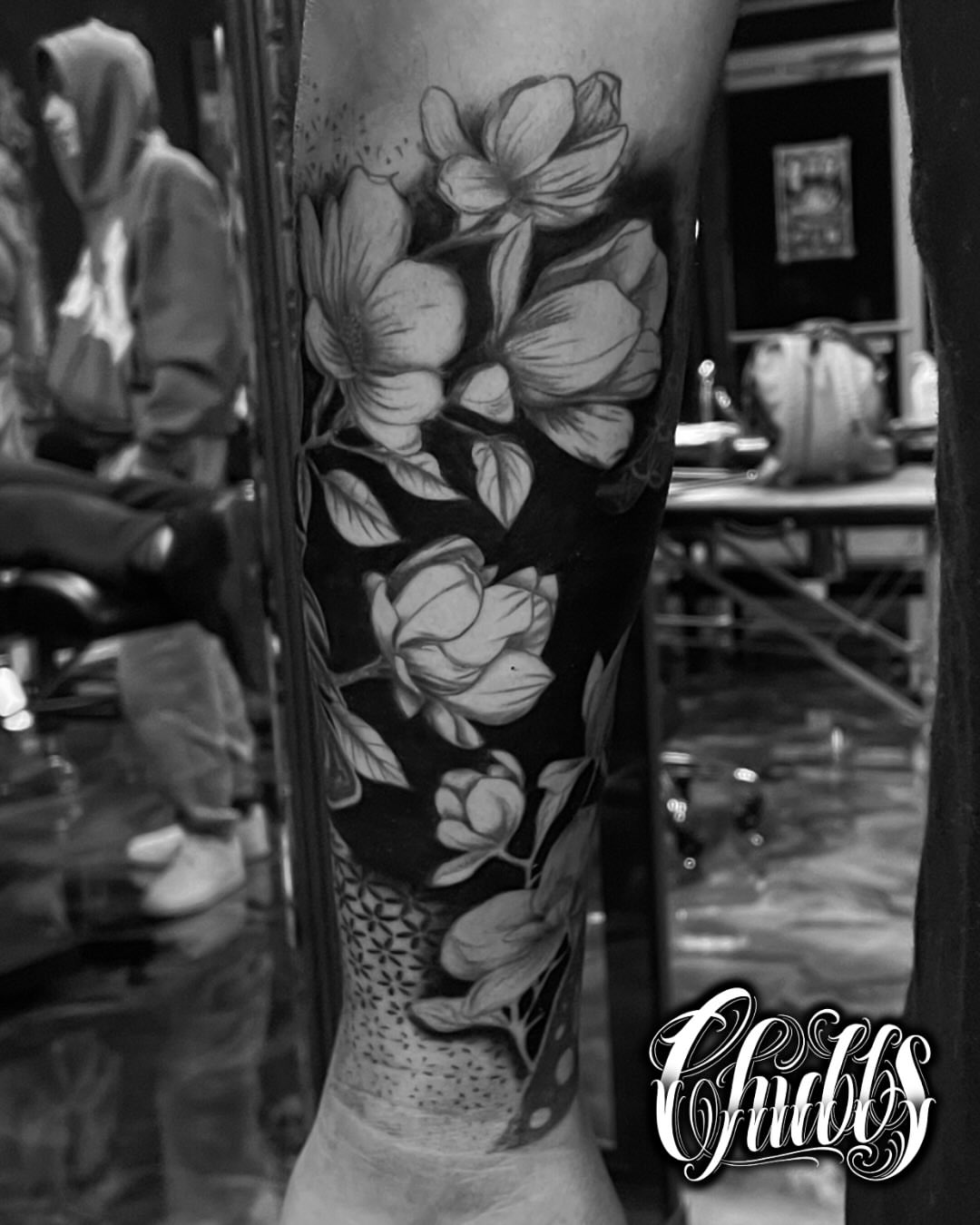 Floral bouquet realism tattoo on the calf by Chubbs
