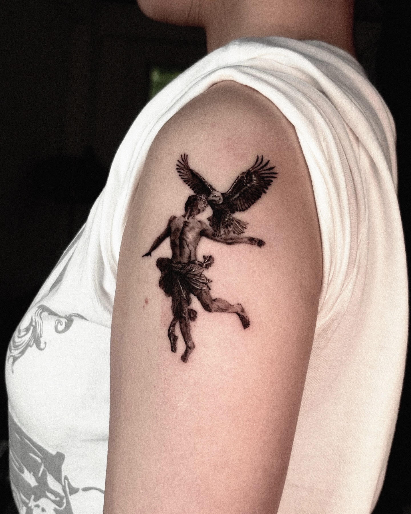 Mythical creature and human realism tattoo on the upper arm by Seraph Geometry