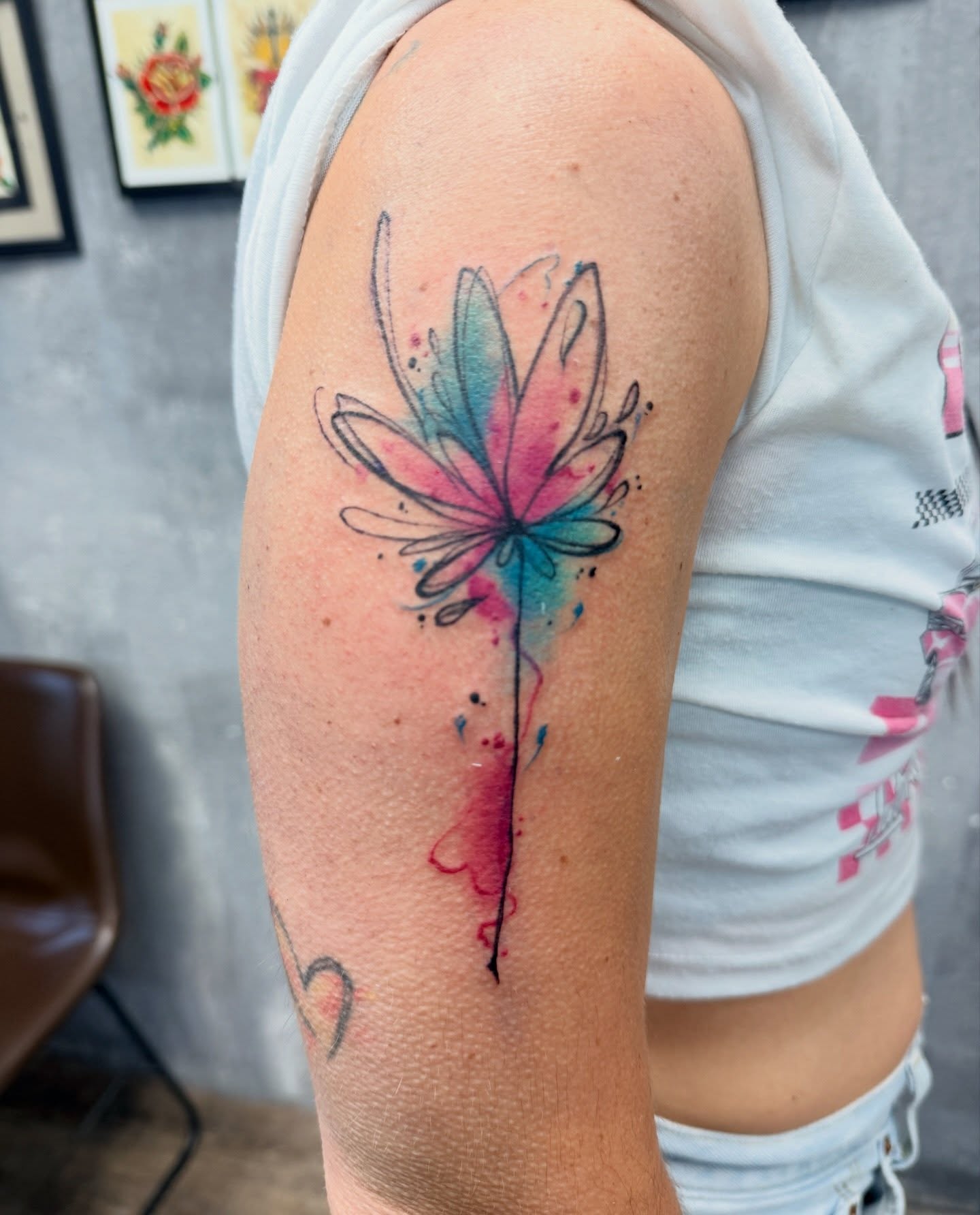 Watercolor flower watercolor tattoo on the upper arm by Chris
