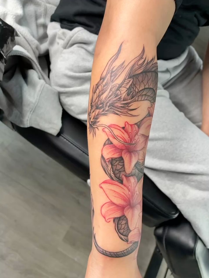 Dragon and lilies realism tattoo on the forearm by Tattoos by Hailey