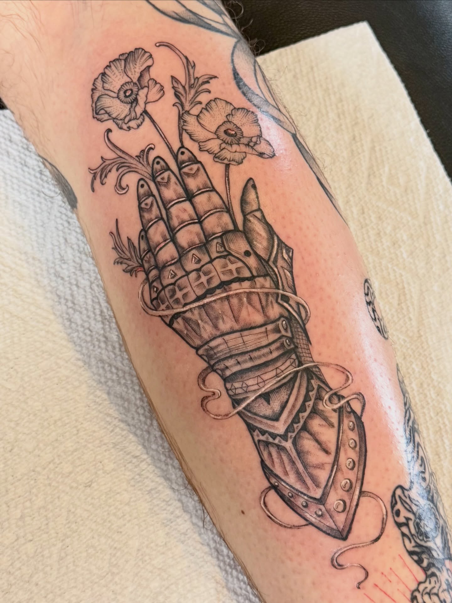Mechanical hand with flowers geometric tattoo on the forearm by Sophia, New Carlisle, Ohio