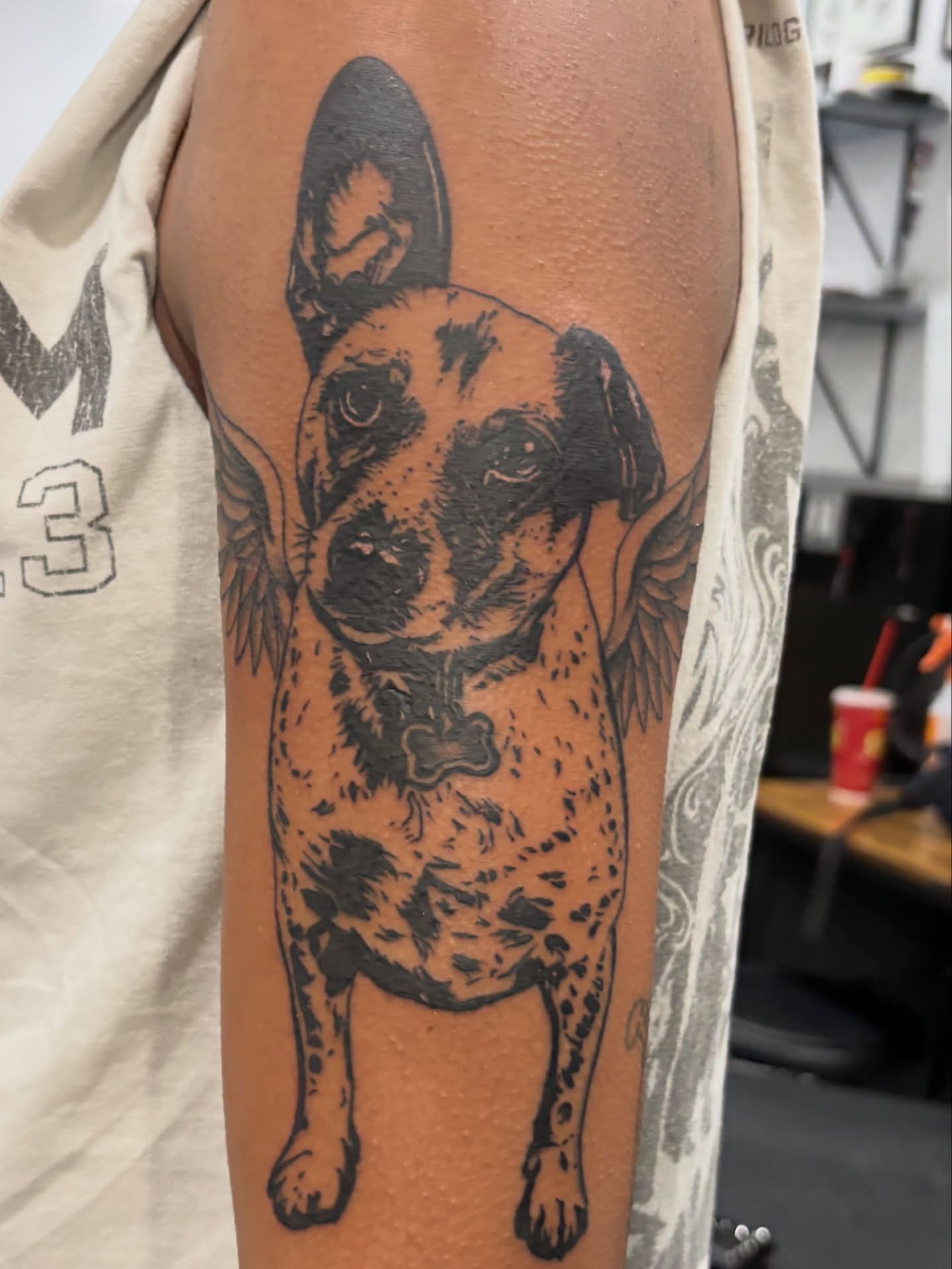 Dog with wings black and grey tattoo on the forearm by Miklo Montoya
