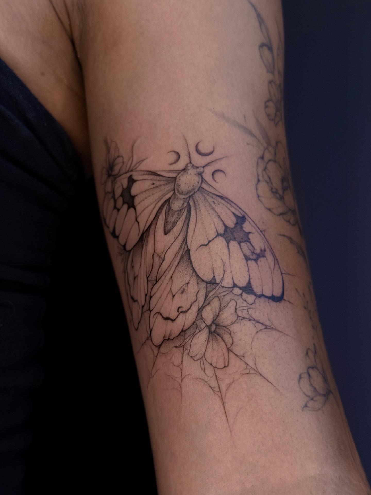 Moth and flowers realism tattoo on the forearm by Daria