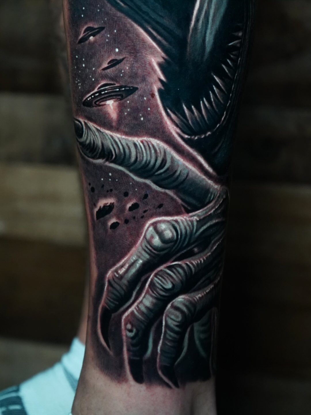 Alien hand reaching towards space dark realism tattoo on the forearm by Edgar Campaña