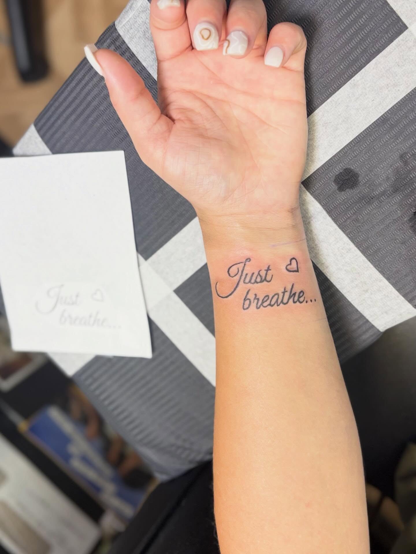Just breathe lettering script tattoo on the forearm by Natalie Jade Shupe