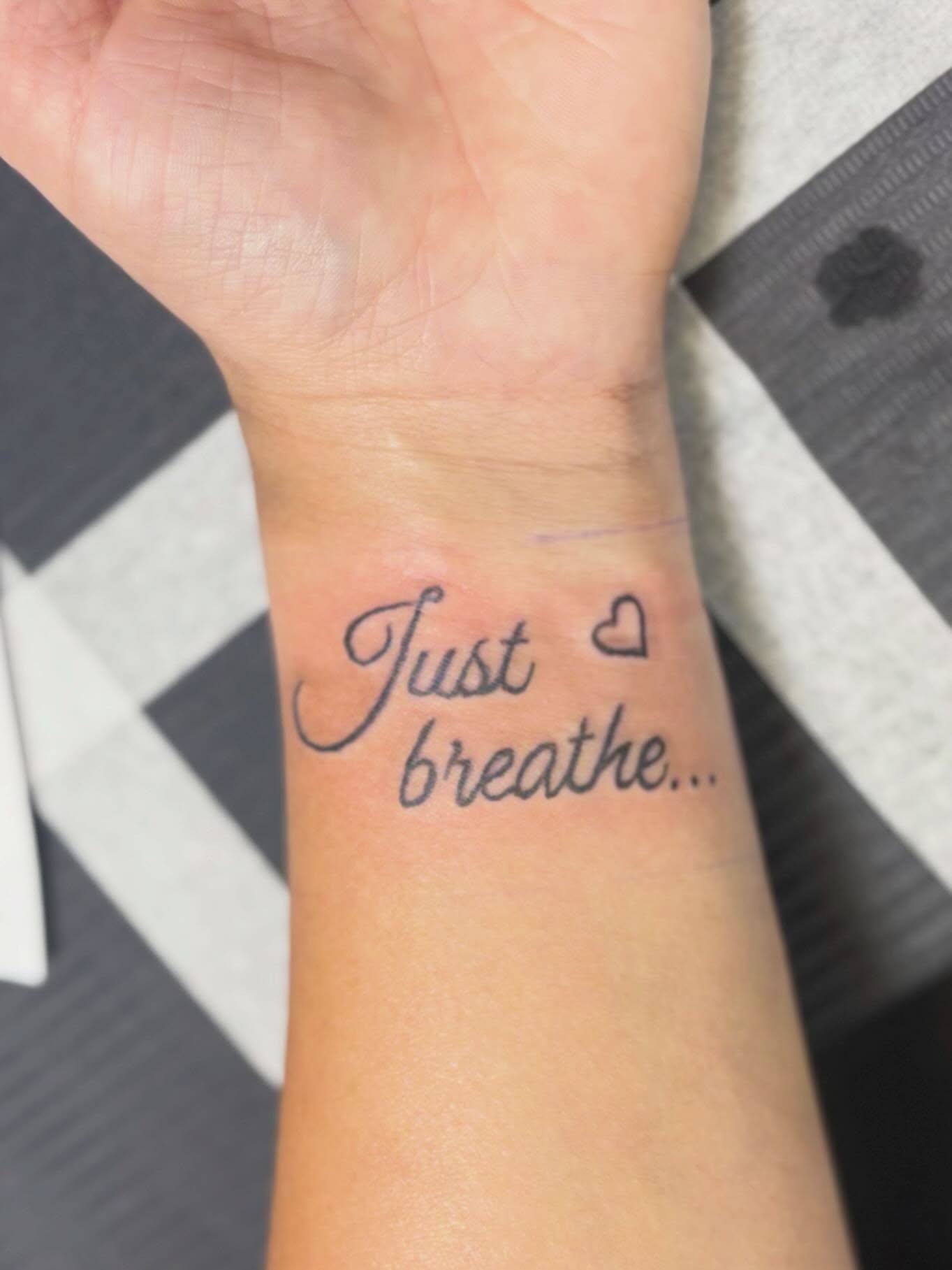Just breathe lettering script tattoo on the forearm by Natalie Jade Shupe