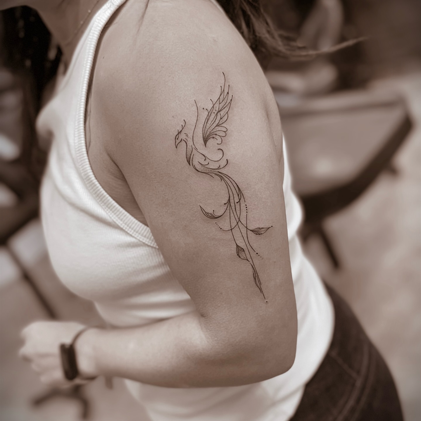 Phoenix fine line tattoo on the upper arm by Chanel Picquelle, Nashville, Tennessee