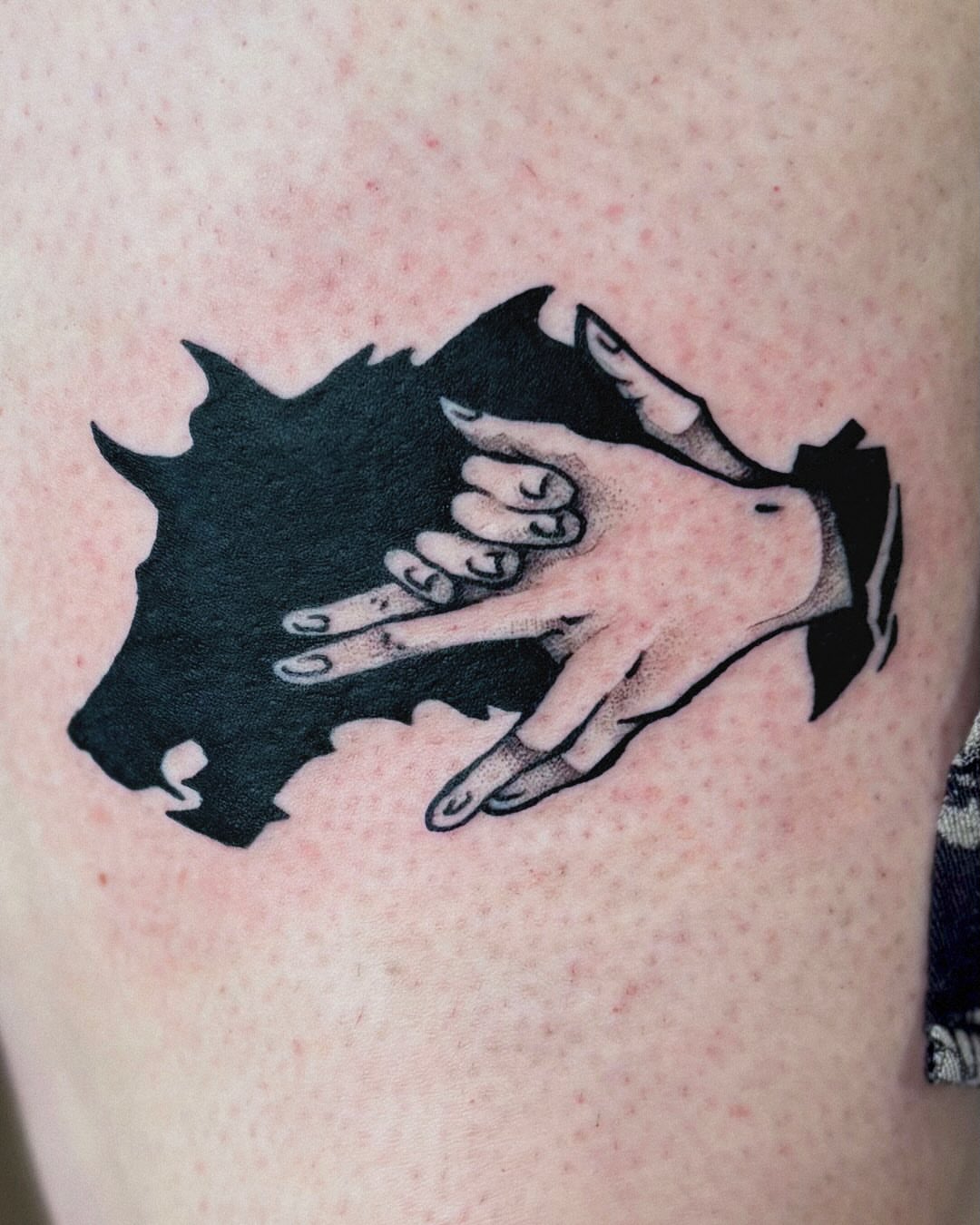Hands reaching through black and grey tattoo on the upper arm by Kal