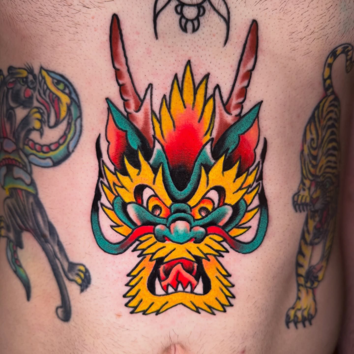 Dragon American traditional tattoo on the chest by Mike Dunn