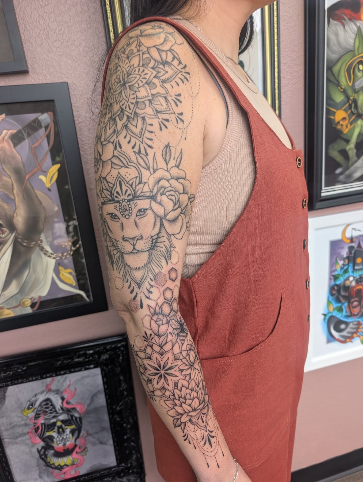 Lion with floral crown dotwork tattoo on the upper arm by Alexandria Green