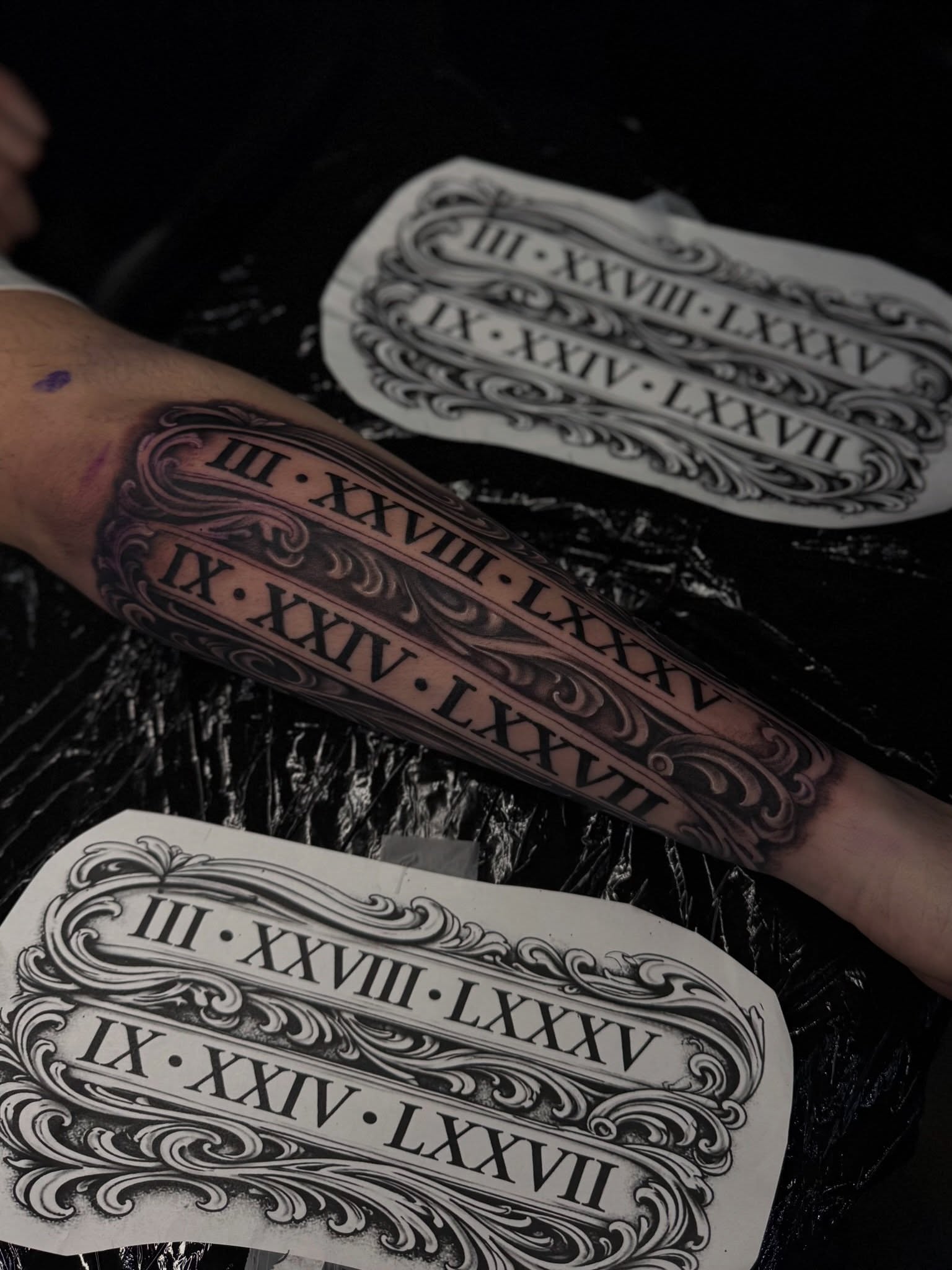 Roman numerals black and grey tattoo on the forearm by Santi🎲